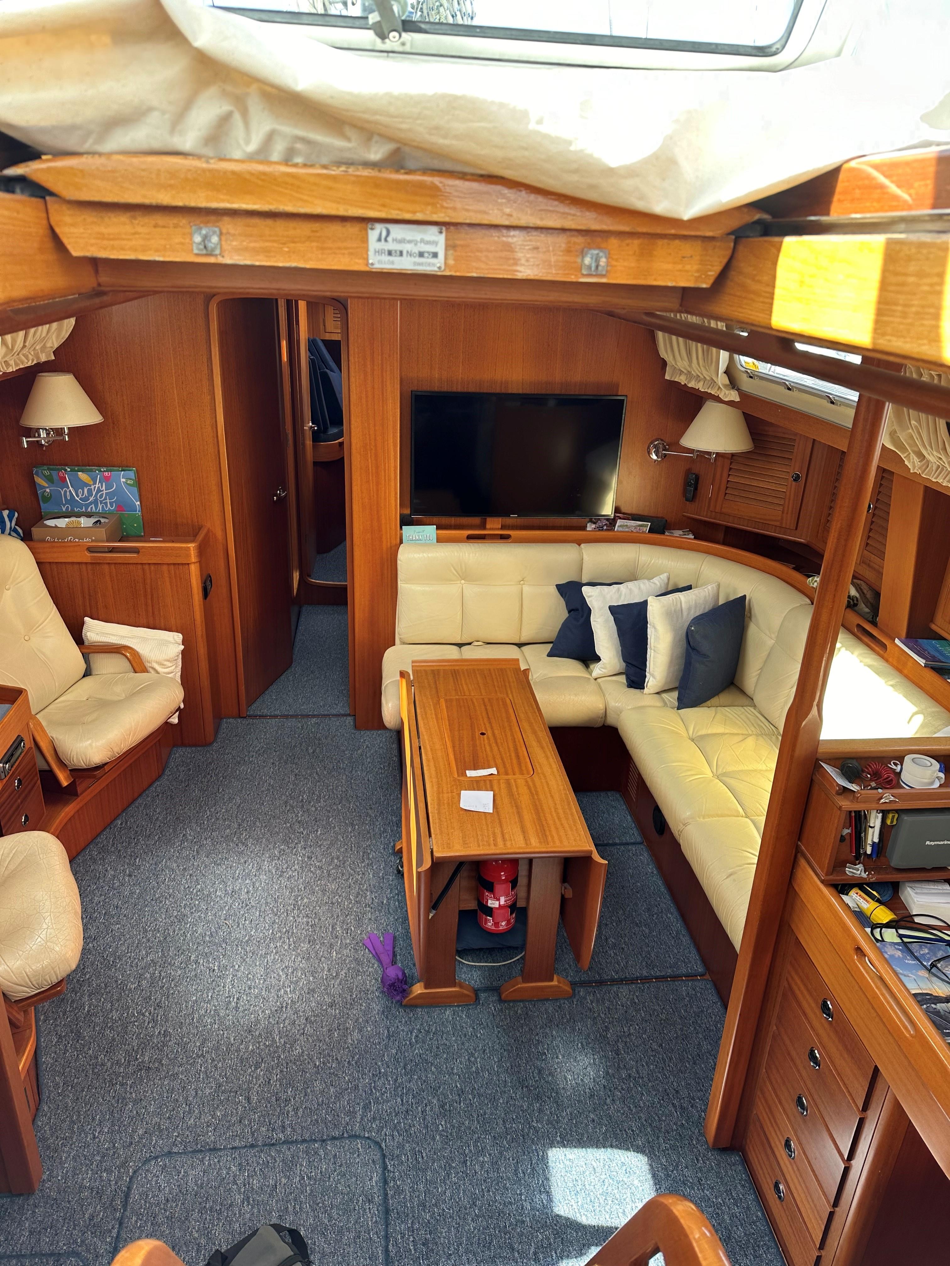 Interior of a 2004 Hallberg-Rassy 53 yacht with cozy living area.