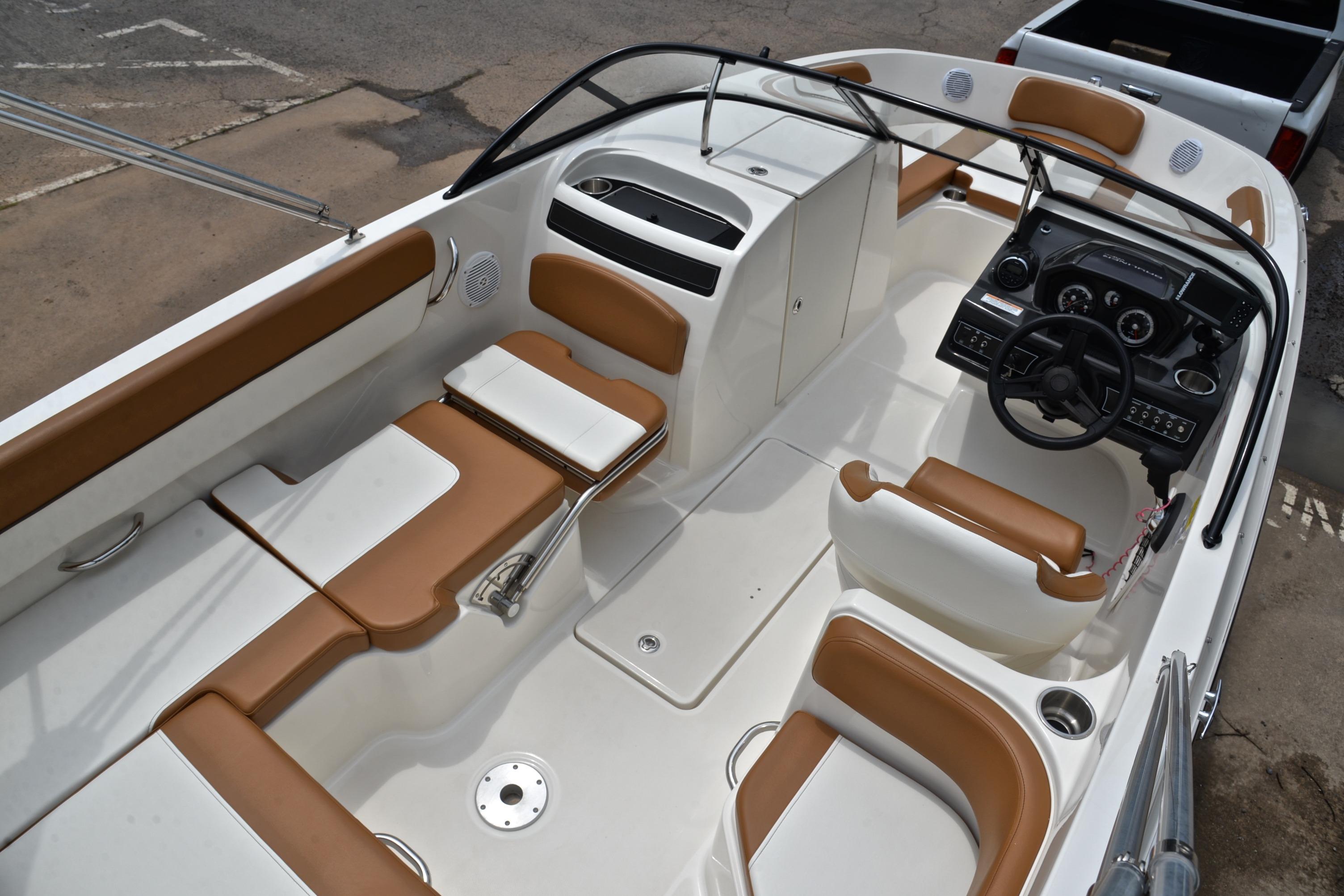 2019 Bayliner VR6 Bowrider OB interior with tan and white seating, steering console, and spacious layout.