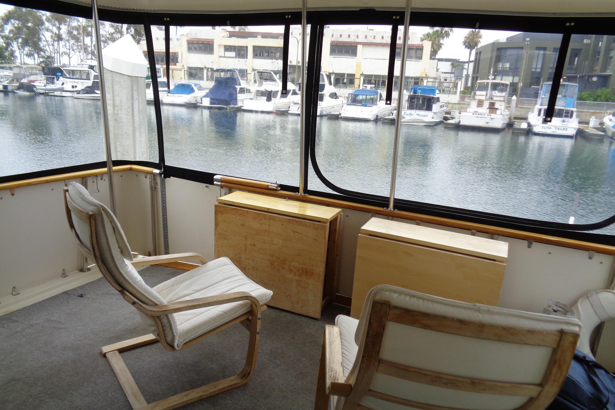 Interior view of 1981 Hatteras 48 Cockpit Motor Yacht with marina backdrop. Sun Deck