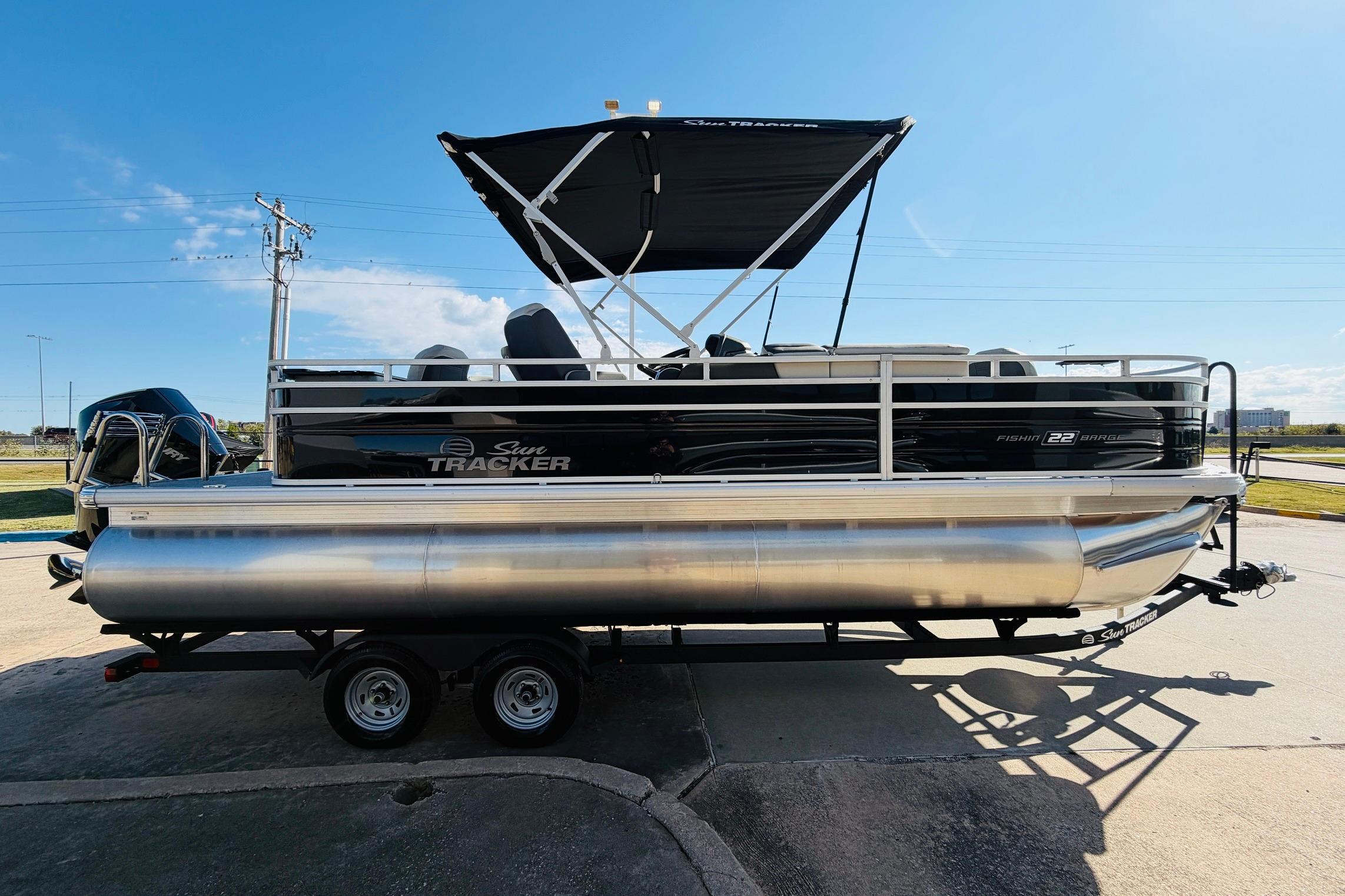 2026 Sun Tracker Fishin' Barge 22 XP3 pontoon boat on trailer, side view.