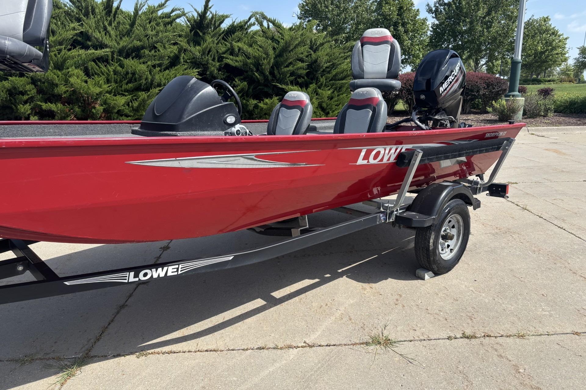 2019 Lowe Skorpion 17 boat in red on a trailer, parked outdoors.