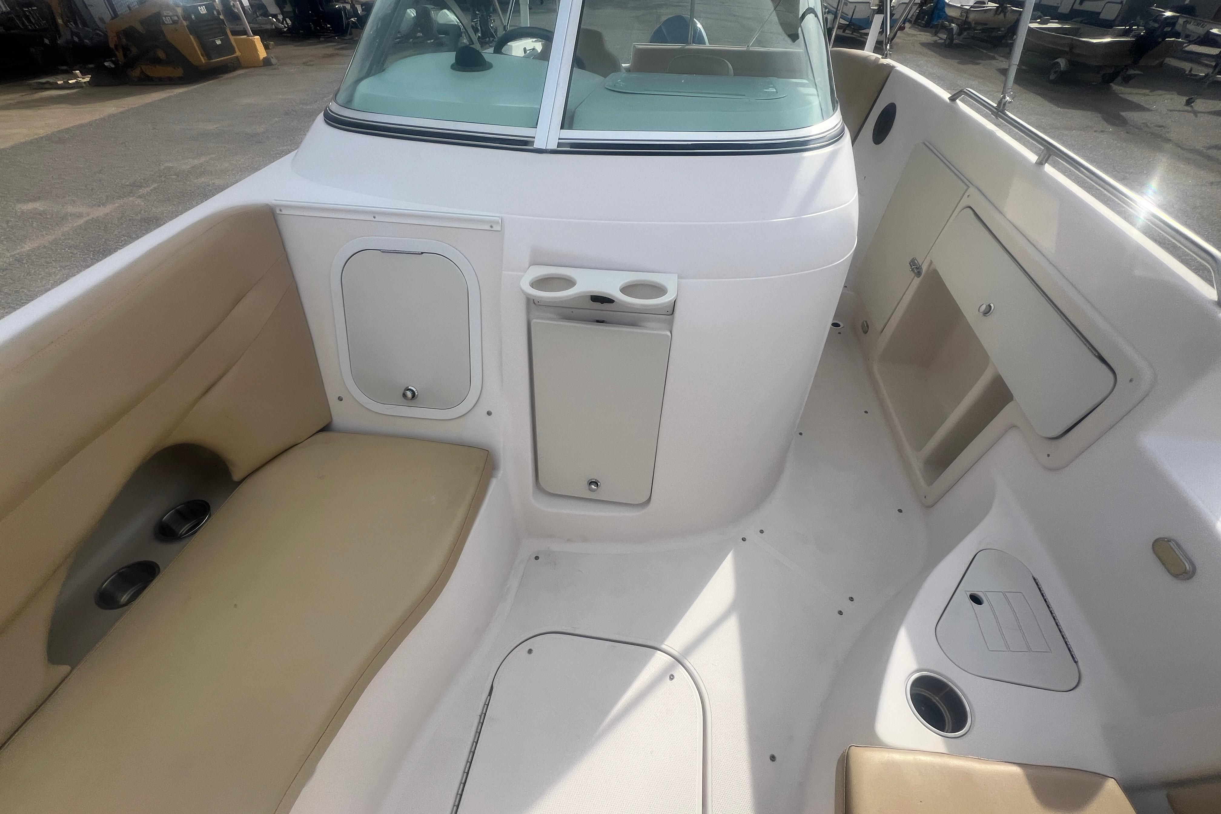 2002 Hurricane SunDeck 260 OB boat interior with seating, storage compartments, and cup holders.