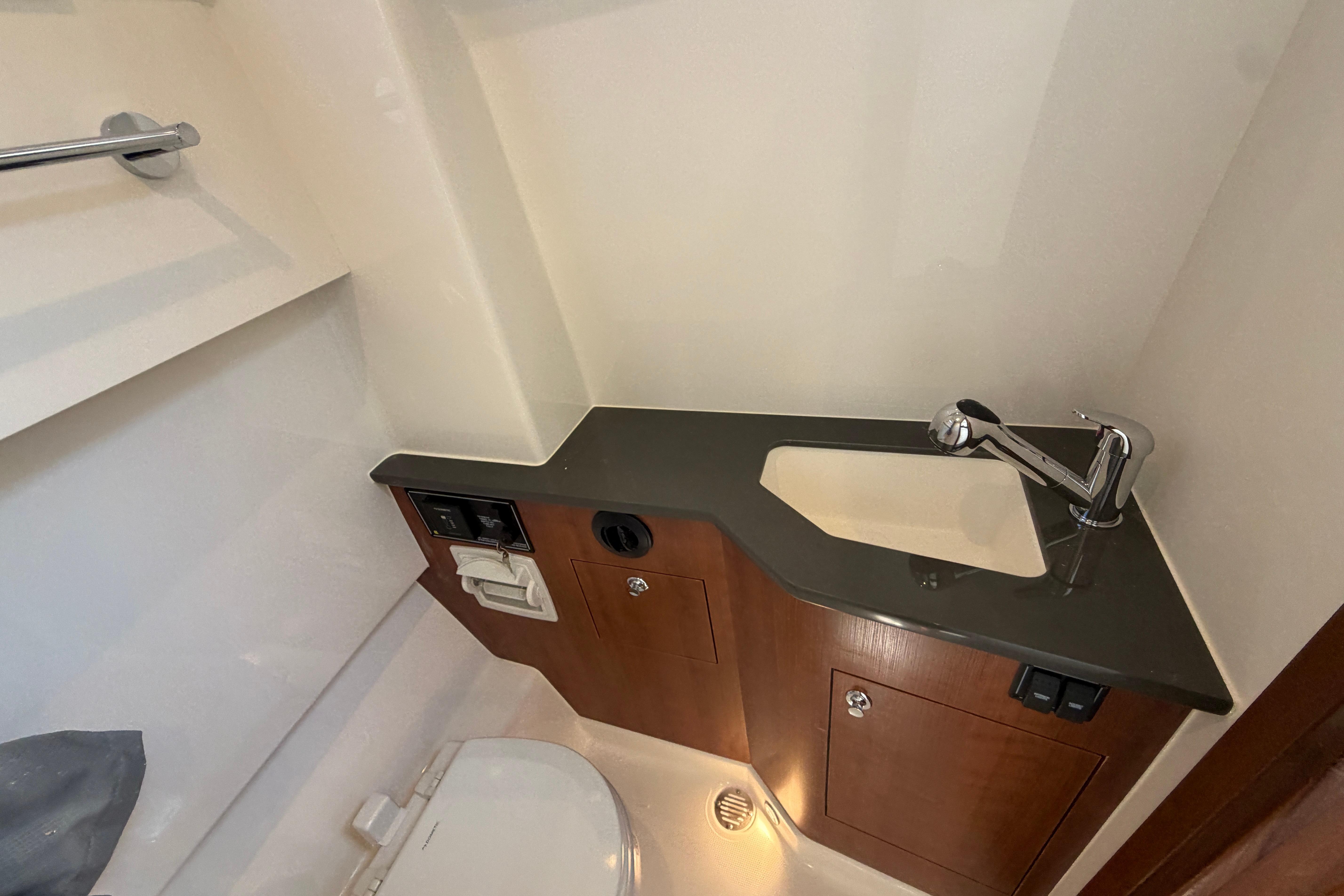 2026 Pursuit S 358 Sport boat bathroom with sink, faucet, and toilet.