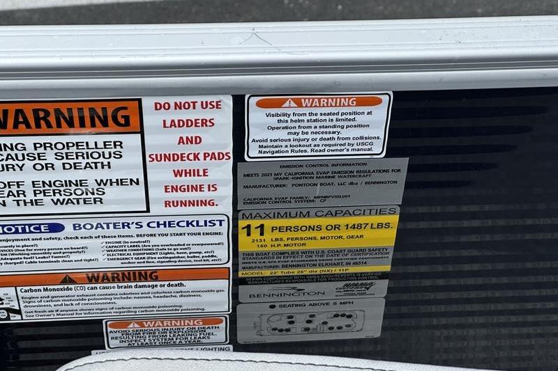 Warning labels on a 2022 Bennington L 23 L-Bench boat, detailing safety and capacity.