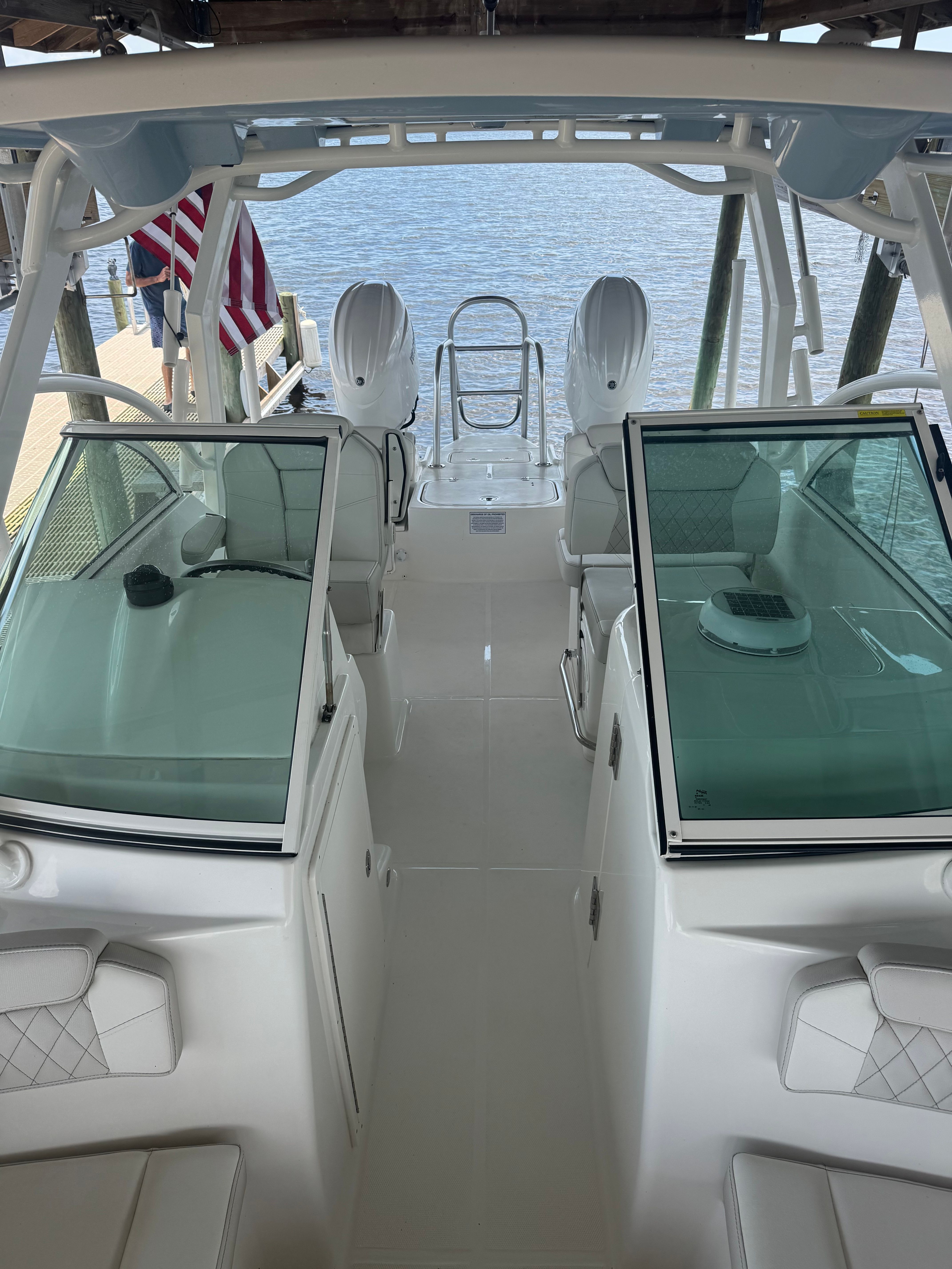 The image shows the cockpit of a World Cat 230 DC boat with two seats and a clear view of the water.
