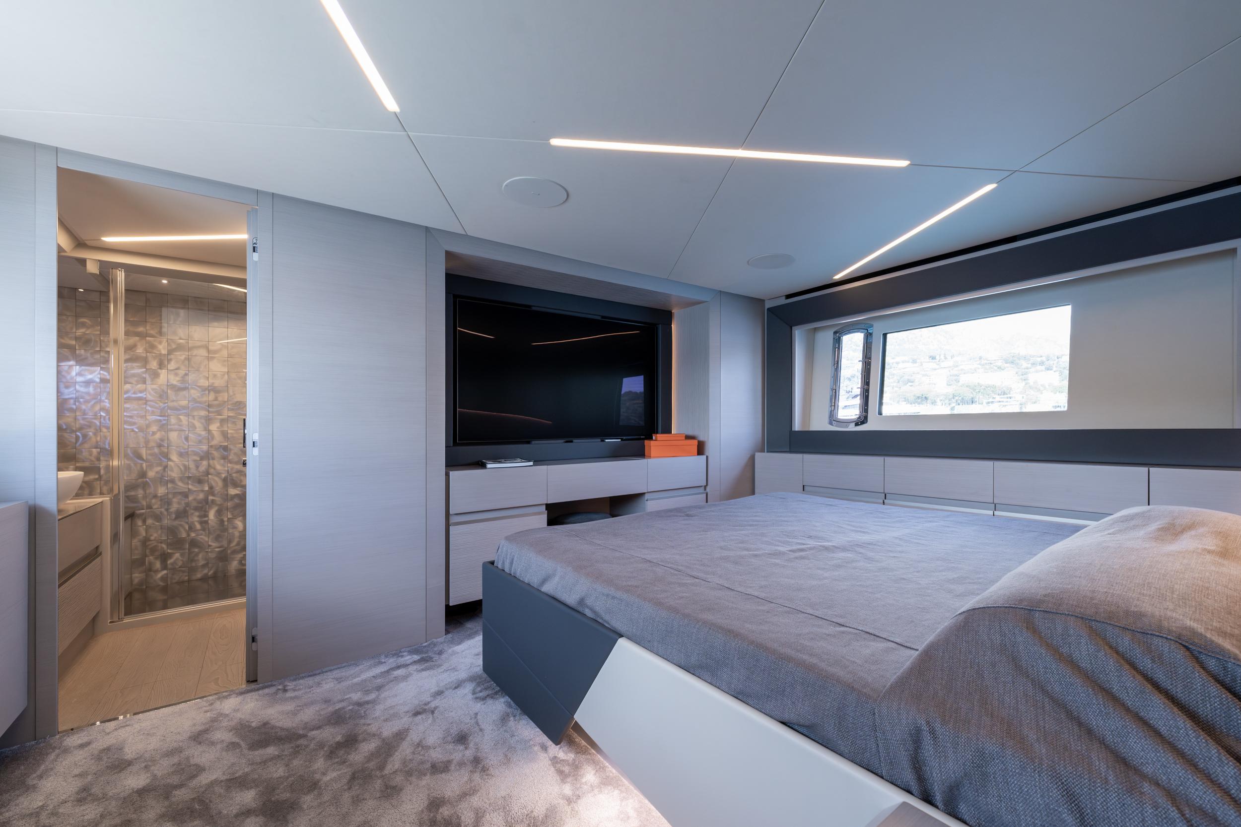 Luxurious interior of 2024 Pershing 7X yacht with modern bedroom and ensuite bathroom.