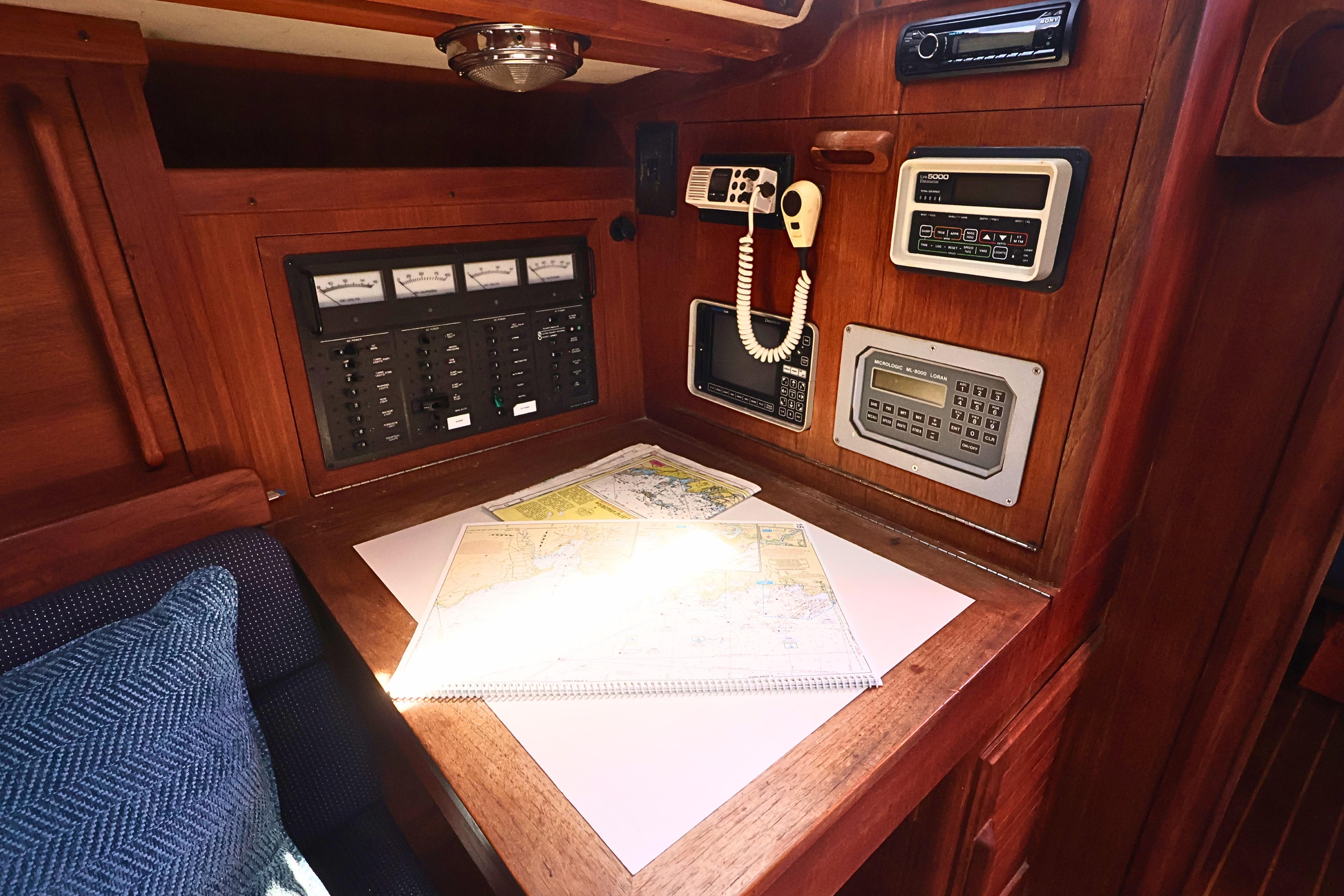 Navigation station on a 1989 J Boat J 40, featuring charts and control panels.