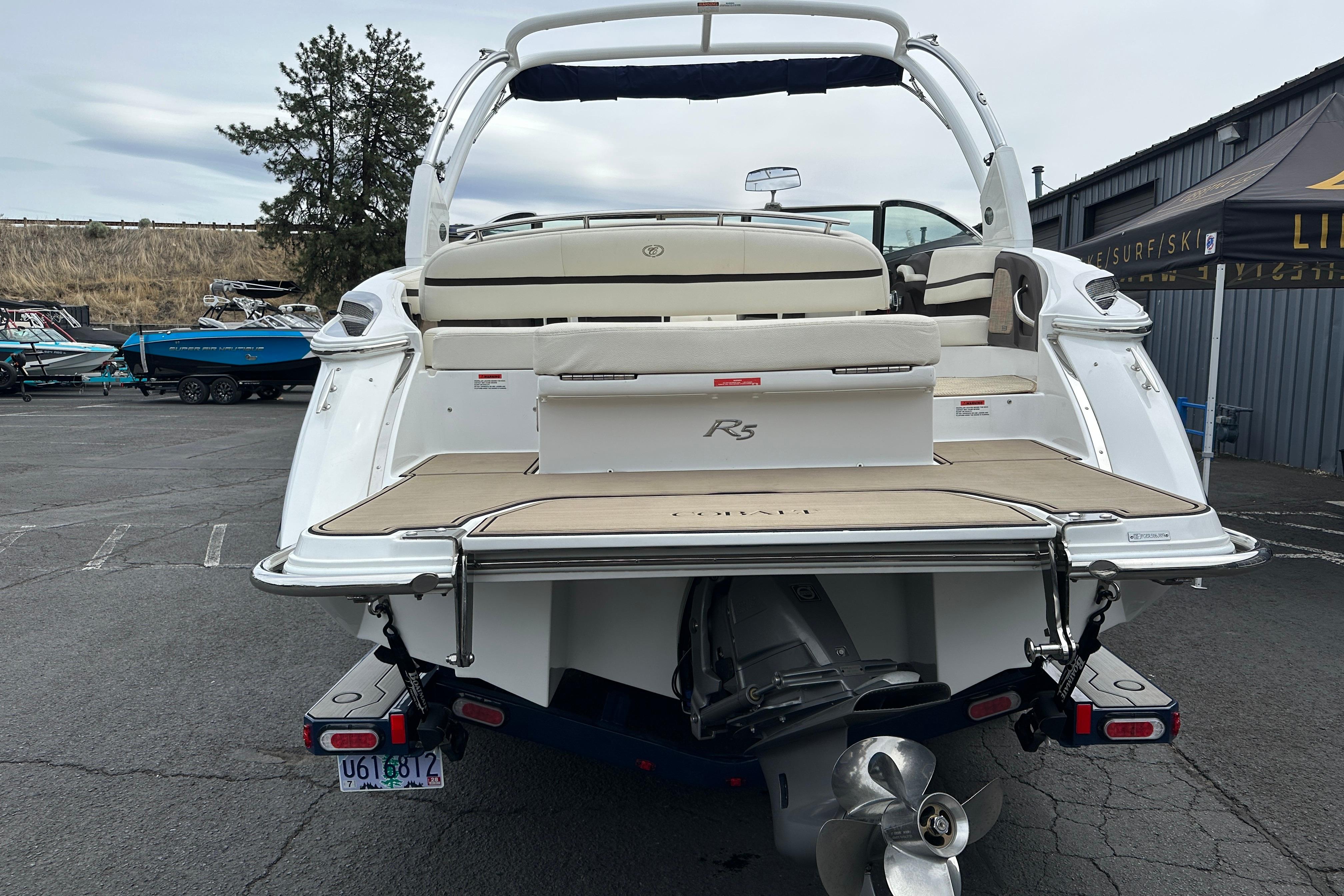 2019 Cobalt R5 boat with beige seating and swim platform, parked outdoors.