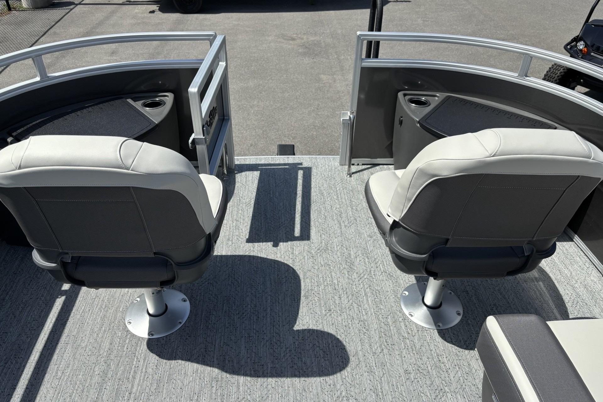 2026 Sun Tracker Fishin' Barge 20 DLX with dual swivel seats and cup holders.