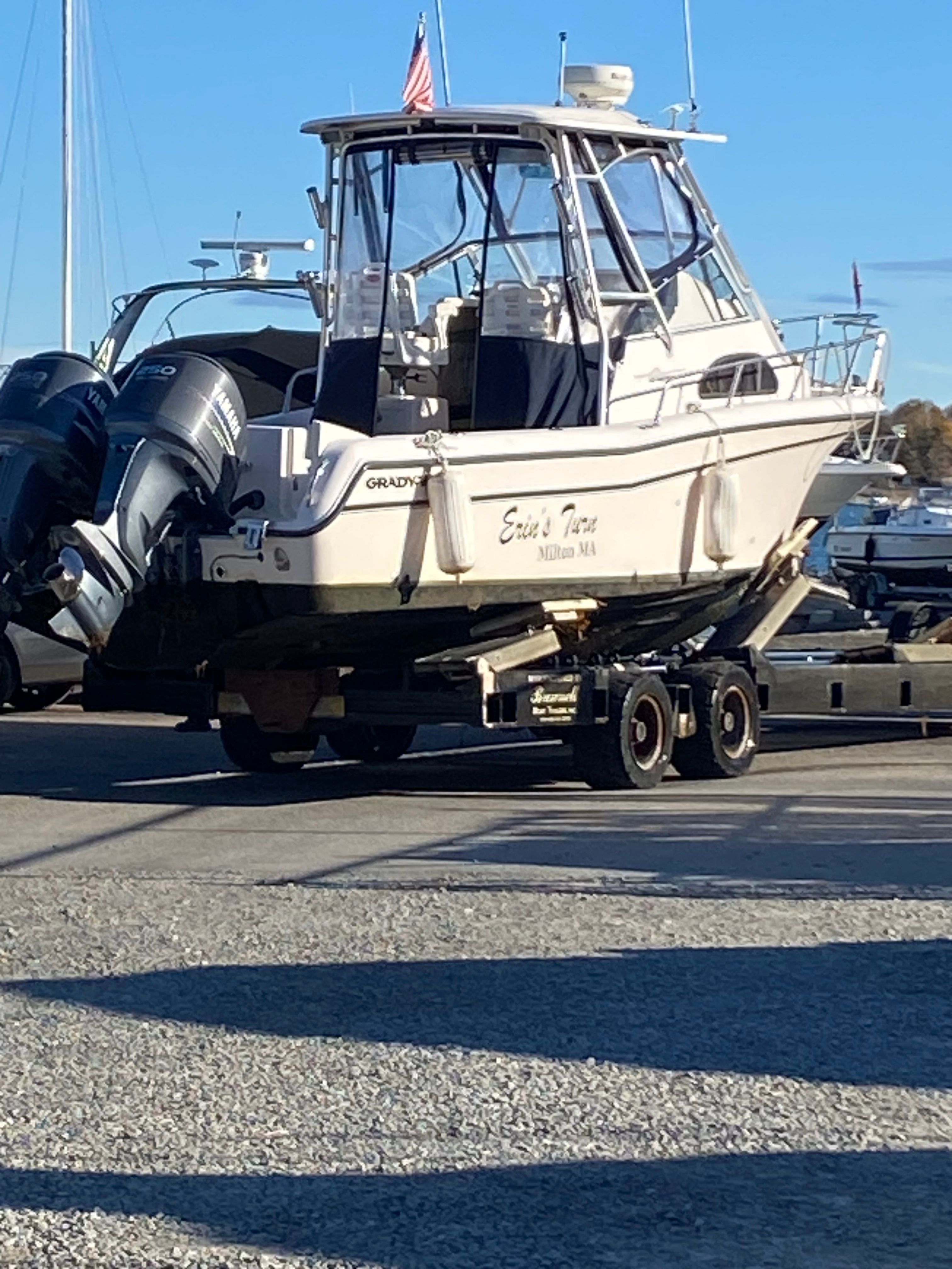 A 2003 Grady-White Sailfish 282 boat is on a trailer in a parking area.