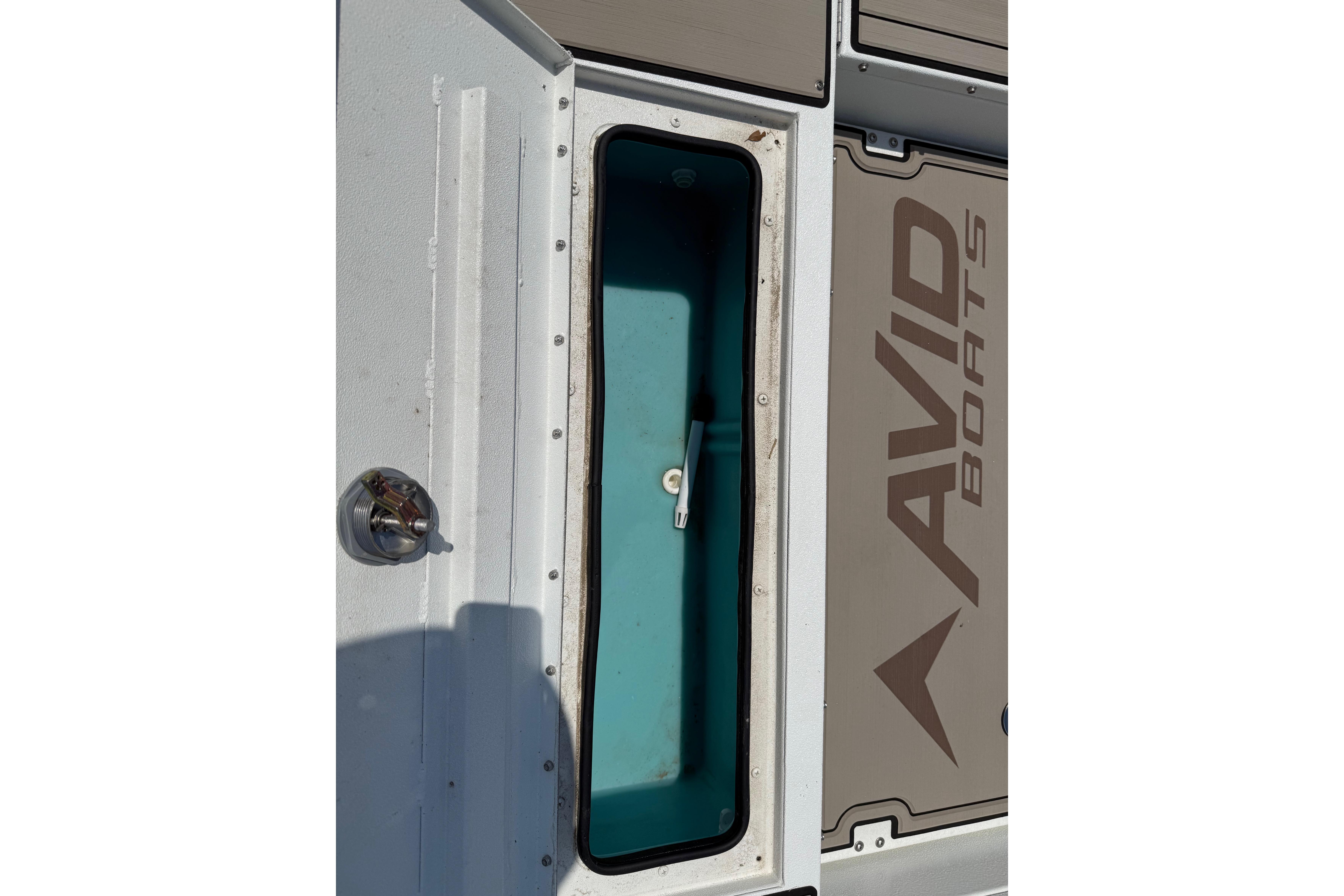 Open storage compartment on 2025 Avid 22 Recon boat, showcasing interior design.