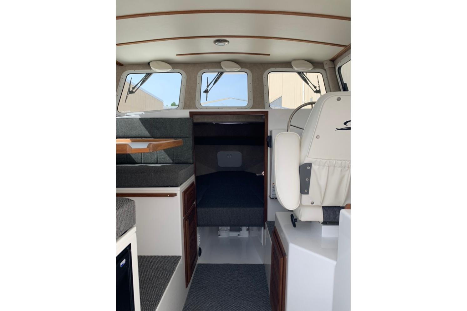 Interior of 2026 Sea Sport Kenai 2600 boat, featuring seating and helm area.
