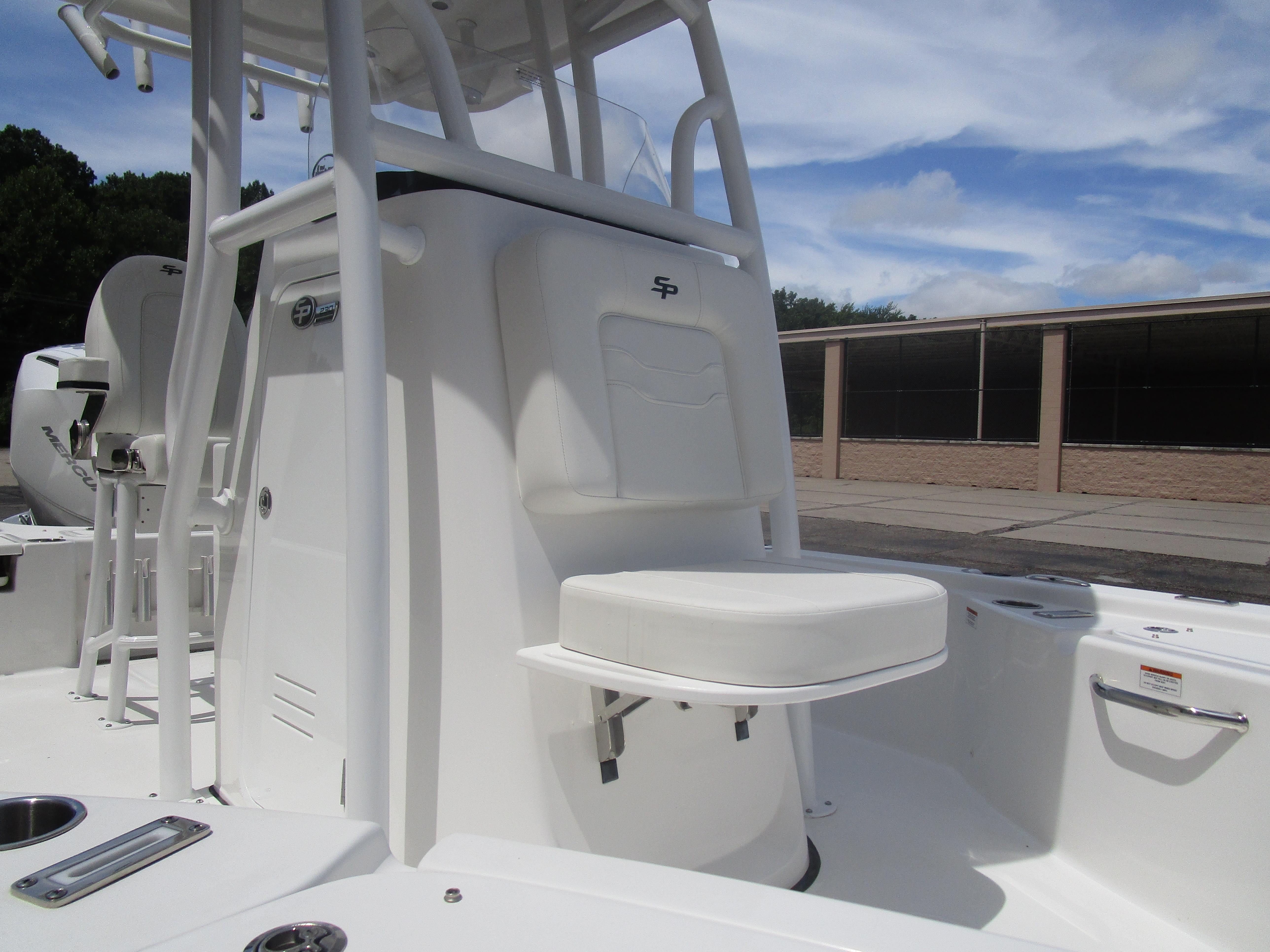 2025 Sea Pro 230 DLX BAY boat interior with seating and console, under a clear sky.