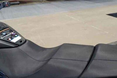 Close-up of a black jet ski seat in an indoor setting.