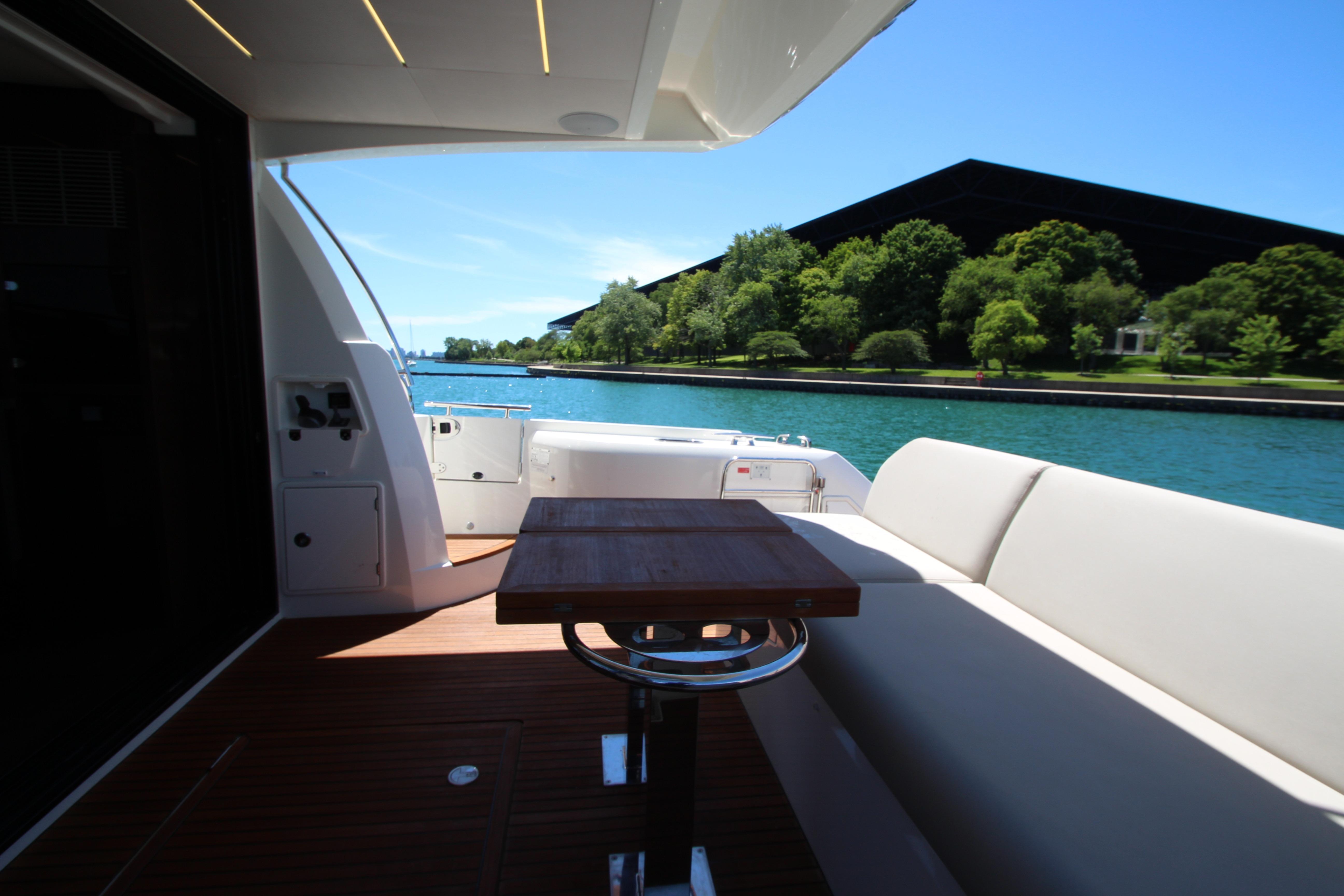 Luxury yacht Prestige 520, 2022 model, with elegant deck and scenic waterfront view.