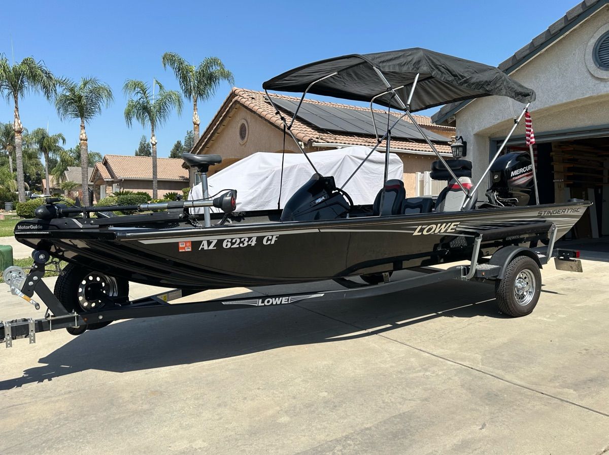A 2018 Lowe Stinger 175C sits on a trailer in a driveway.
