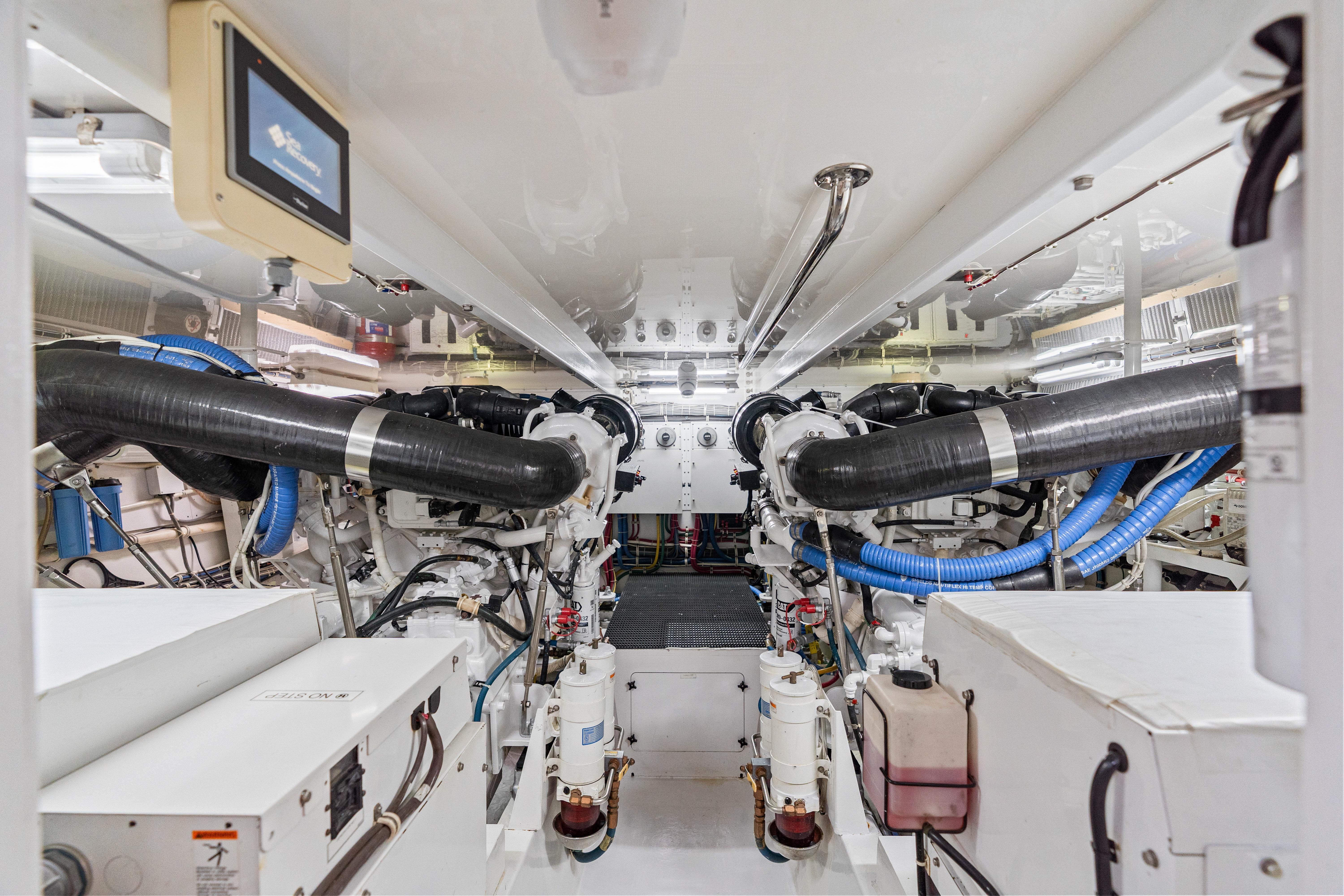Engine room of a 2008 Hatteras 64 Motor Yacht, showcasing dual engines and mechanical systems.