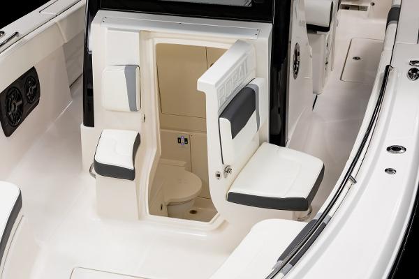 Manufacturer Provided Image: 2025 Robalo R300 Center Console boat interior with seating and compact restroom.