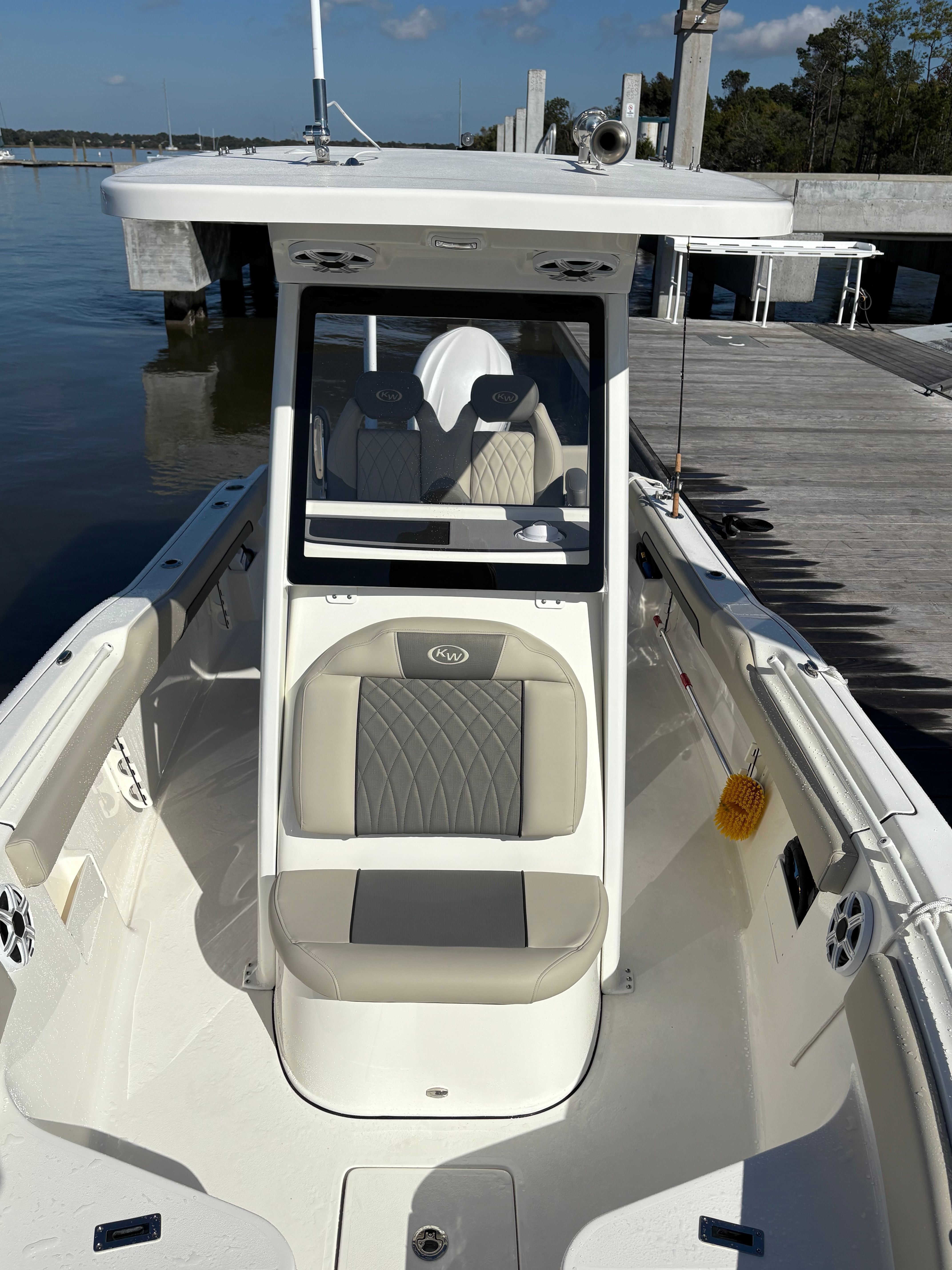 A 2025 Key West 239 FSR boat at a dock, featuring cushioned seating and a modern design.