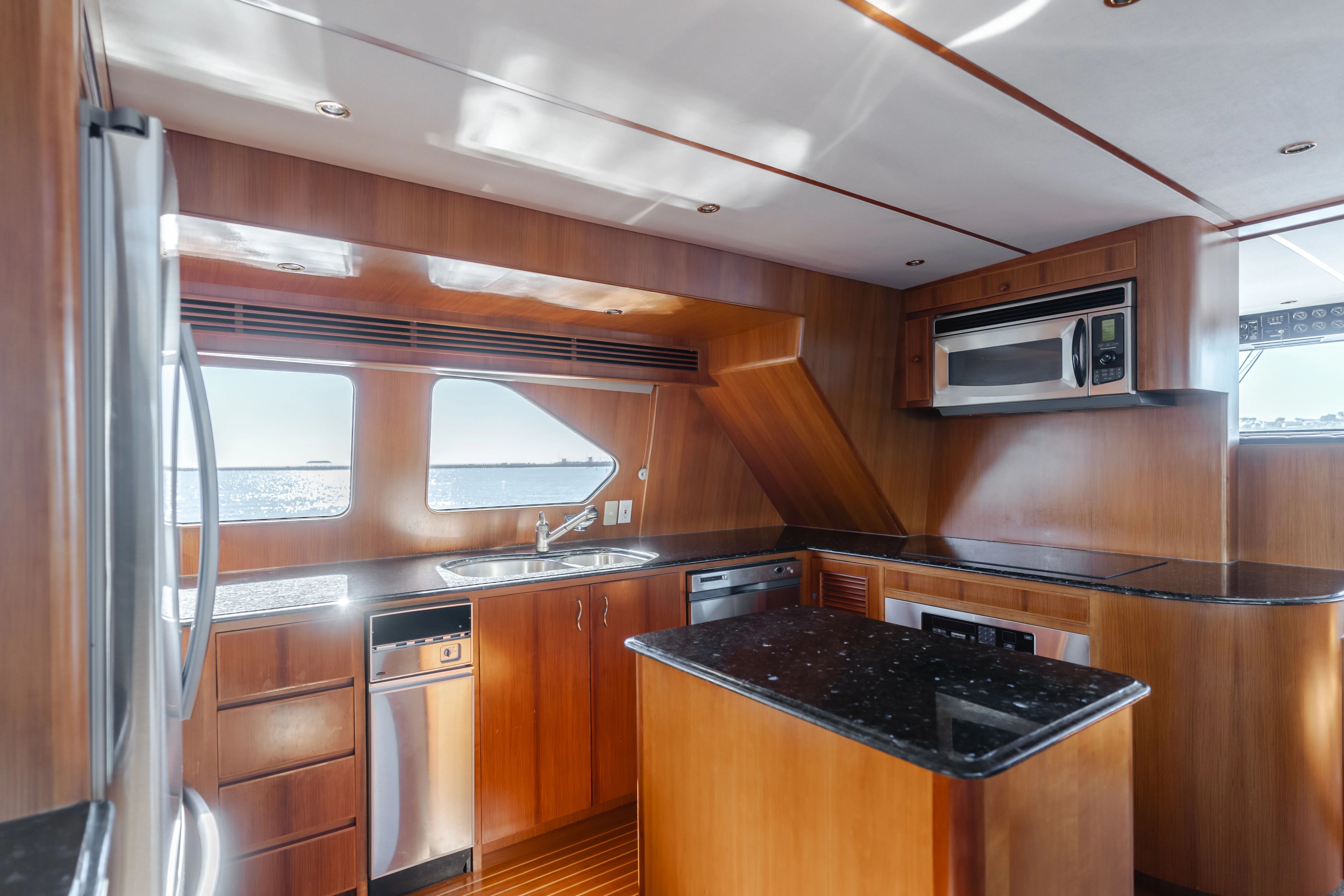 Luxurious yacht kitchen with wood paneling and modern appliances, TransWorld CUSTOM 2003.