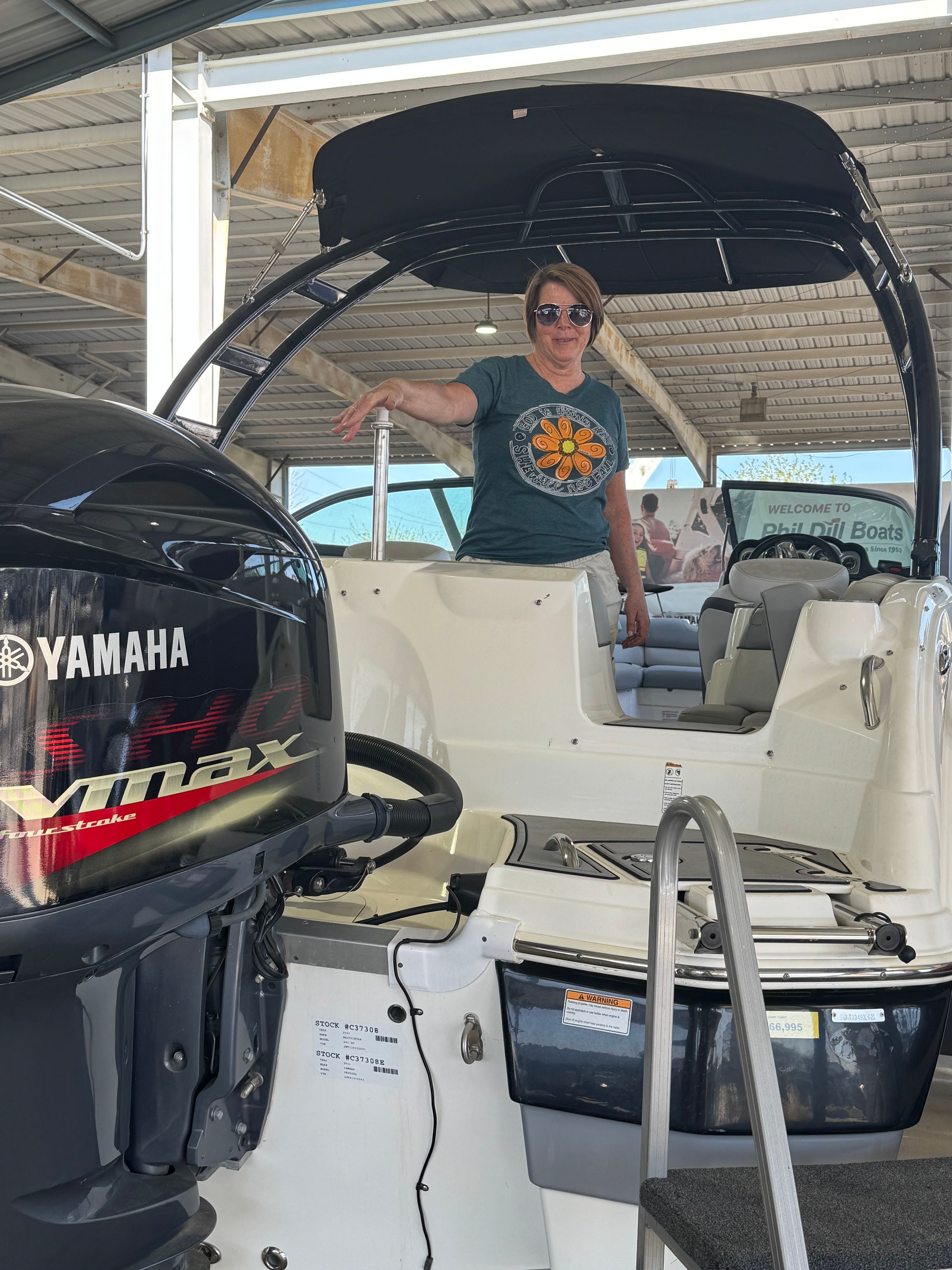 A person stands on a NauticStar 243 DC boat with a Yamaha Vmax engine.