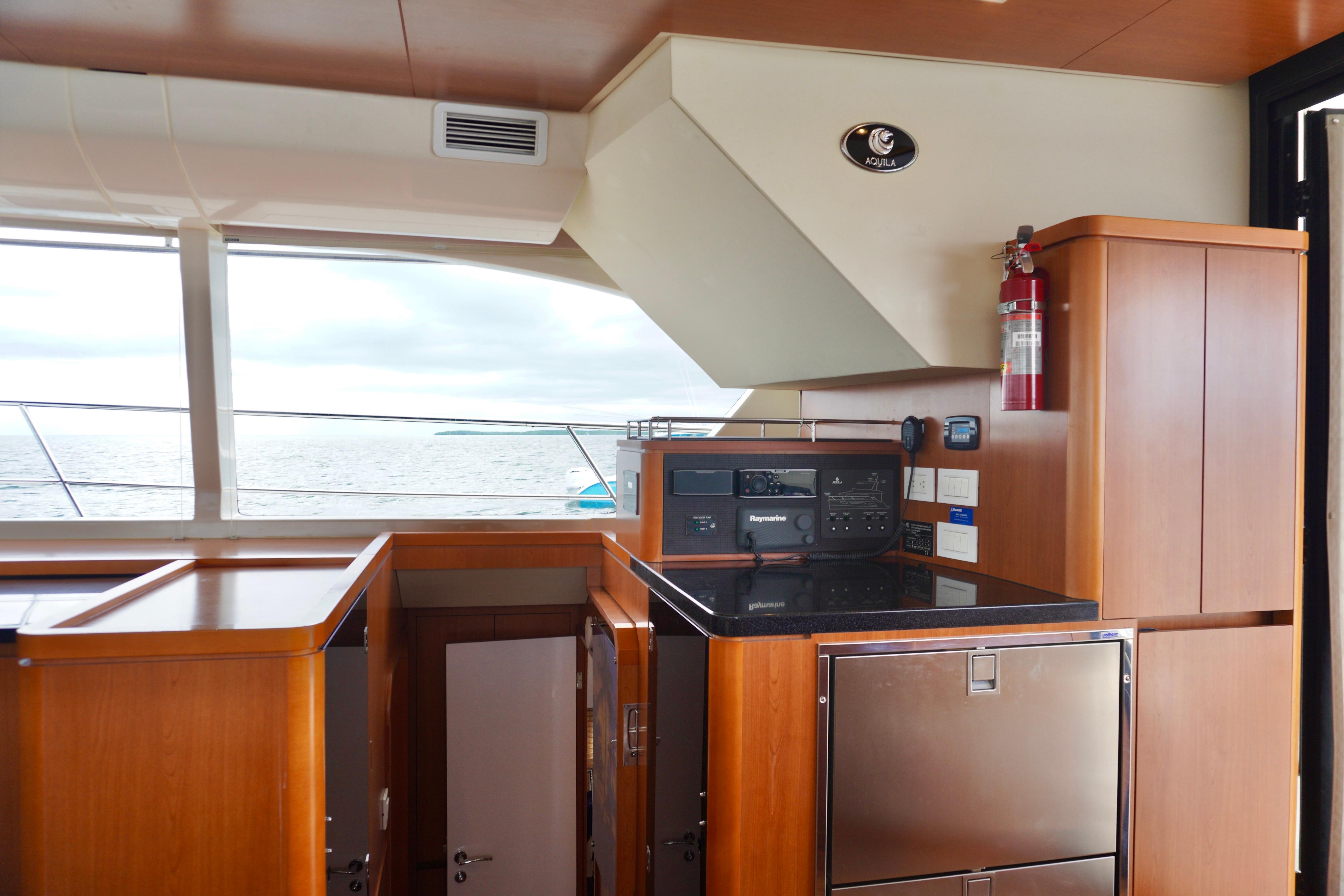 Interior of 2017 Aquila 44 Yacht with wooden cabinetry and ocean view.