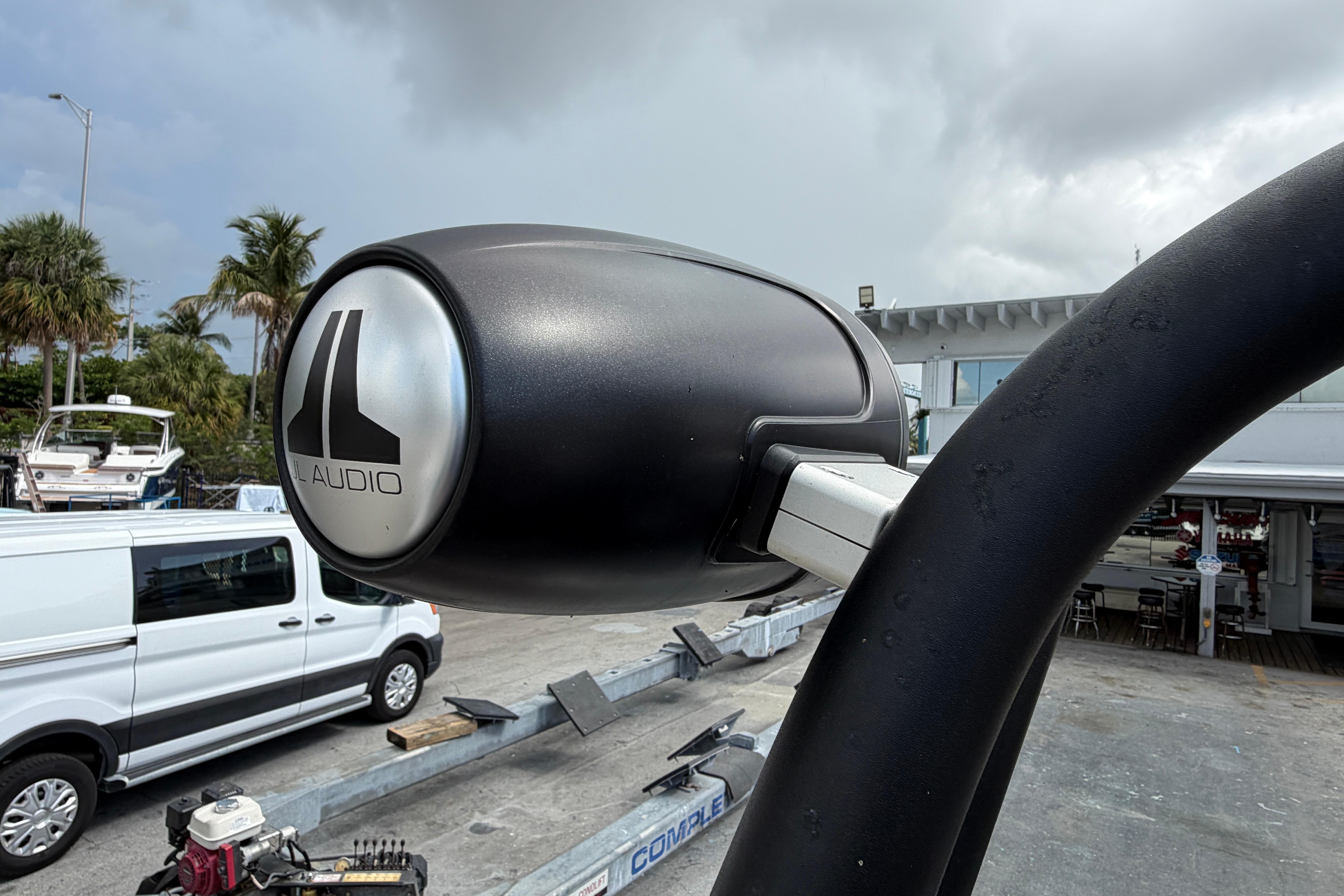 Close-up of JL Audio speaker on 2026 Scarab 235 LX boat, with cloudy sky background.
