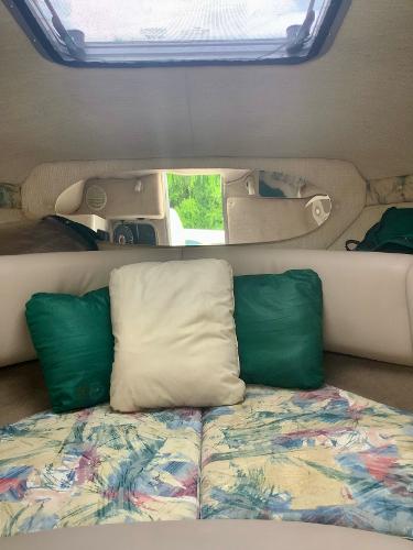 Interior cabin of 1998 Chaparral 2335 SS boat with cushions and skylight.