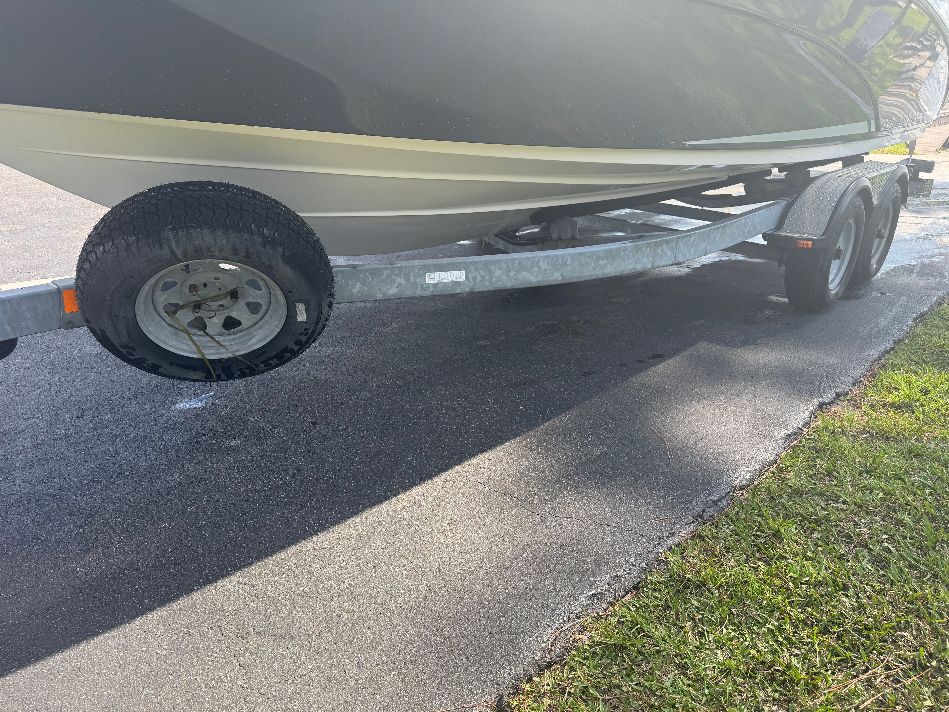 A 2015 Yamaha 242 Limited S boat on a trailer, parked on a paved surface.