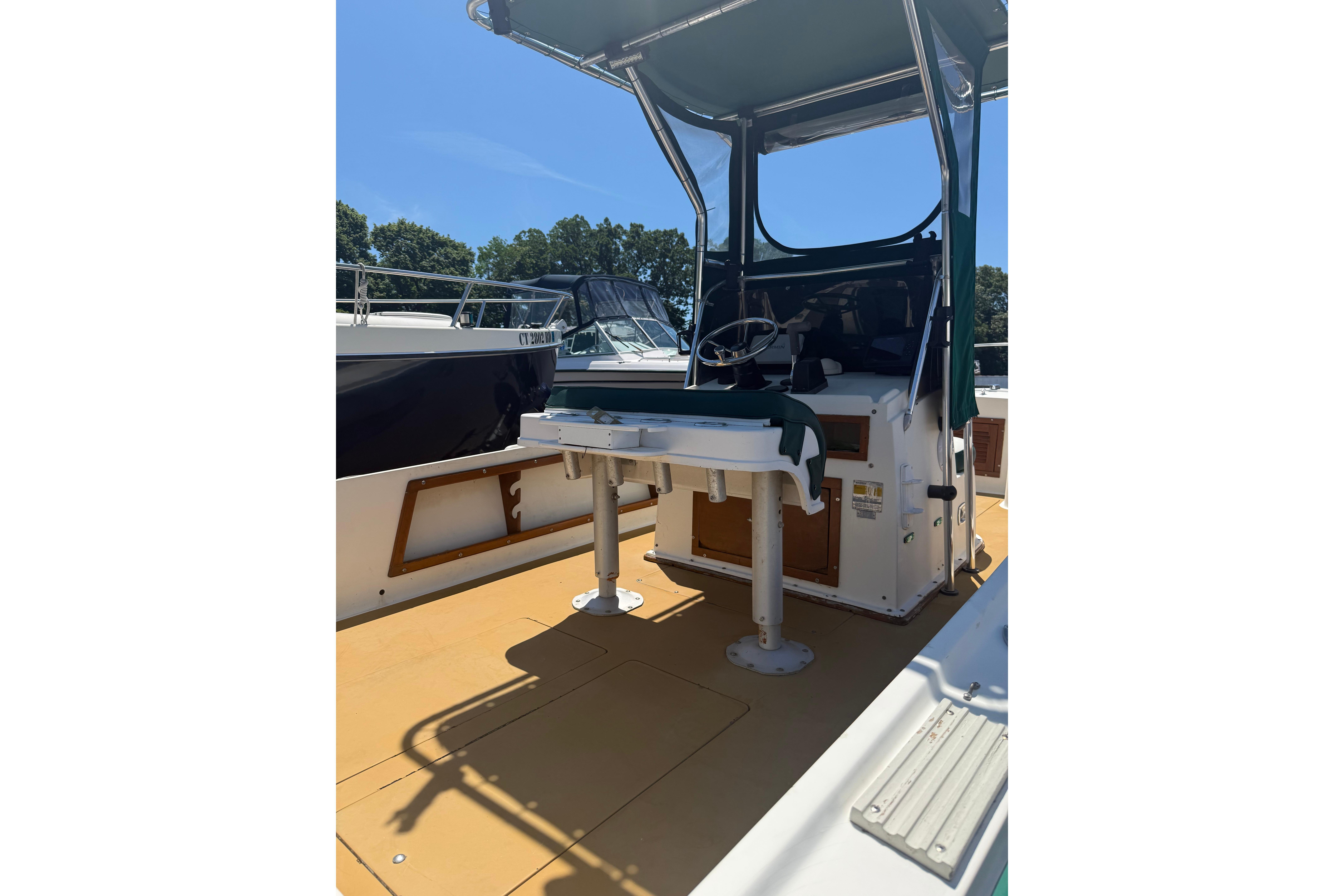 1982 Mako 20 Center Console boat with canopy and steering console, docked under clear sky.