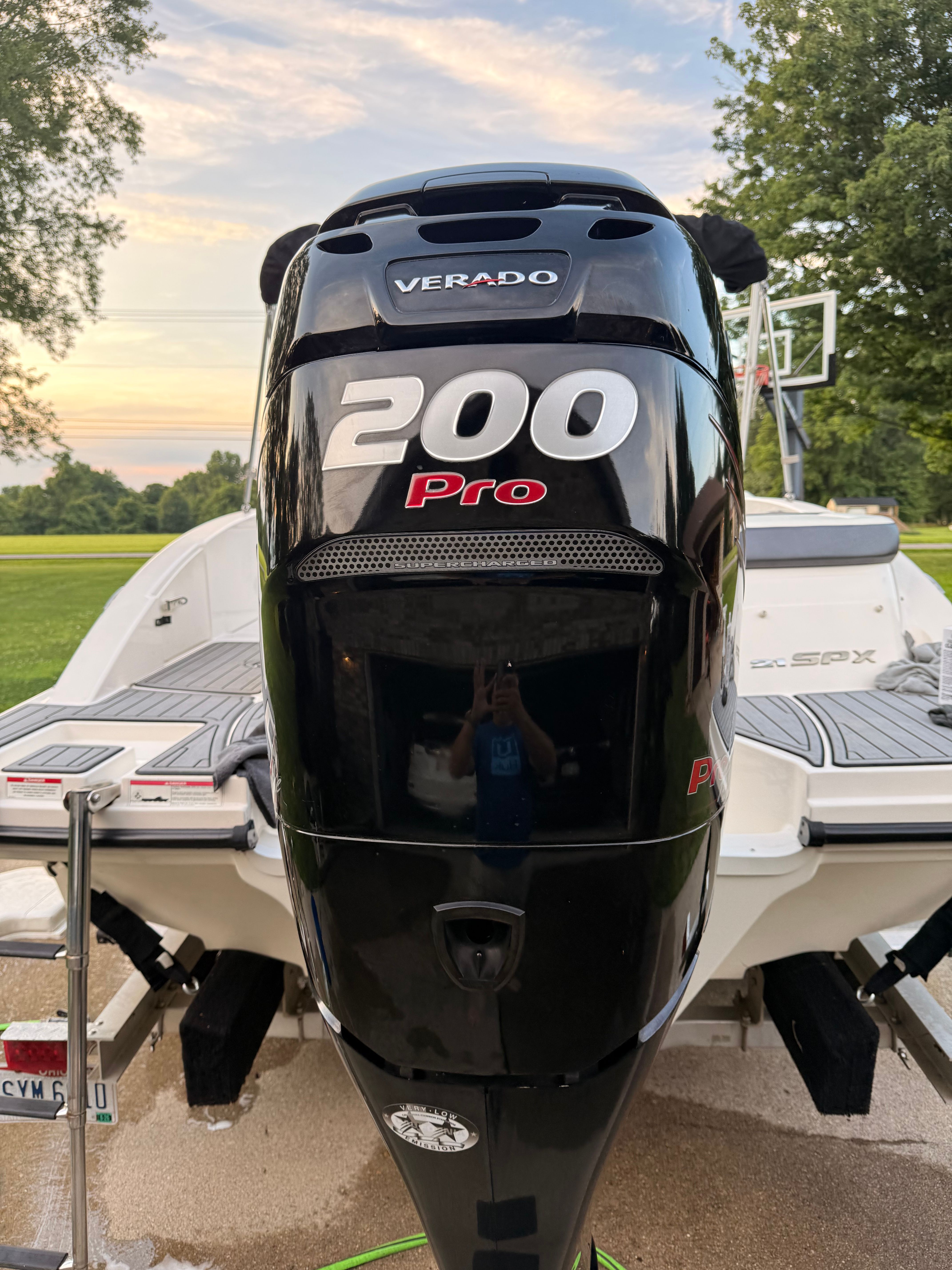 A 2016 Sea Ray SPX 210 Outboard with a 200 HP Verado engine, parked in a yard.