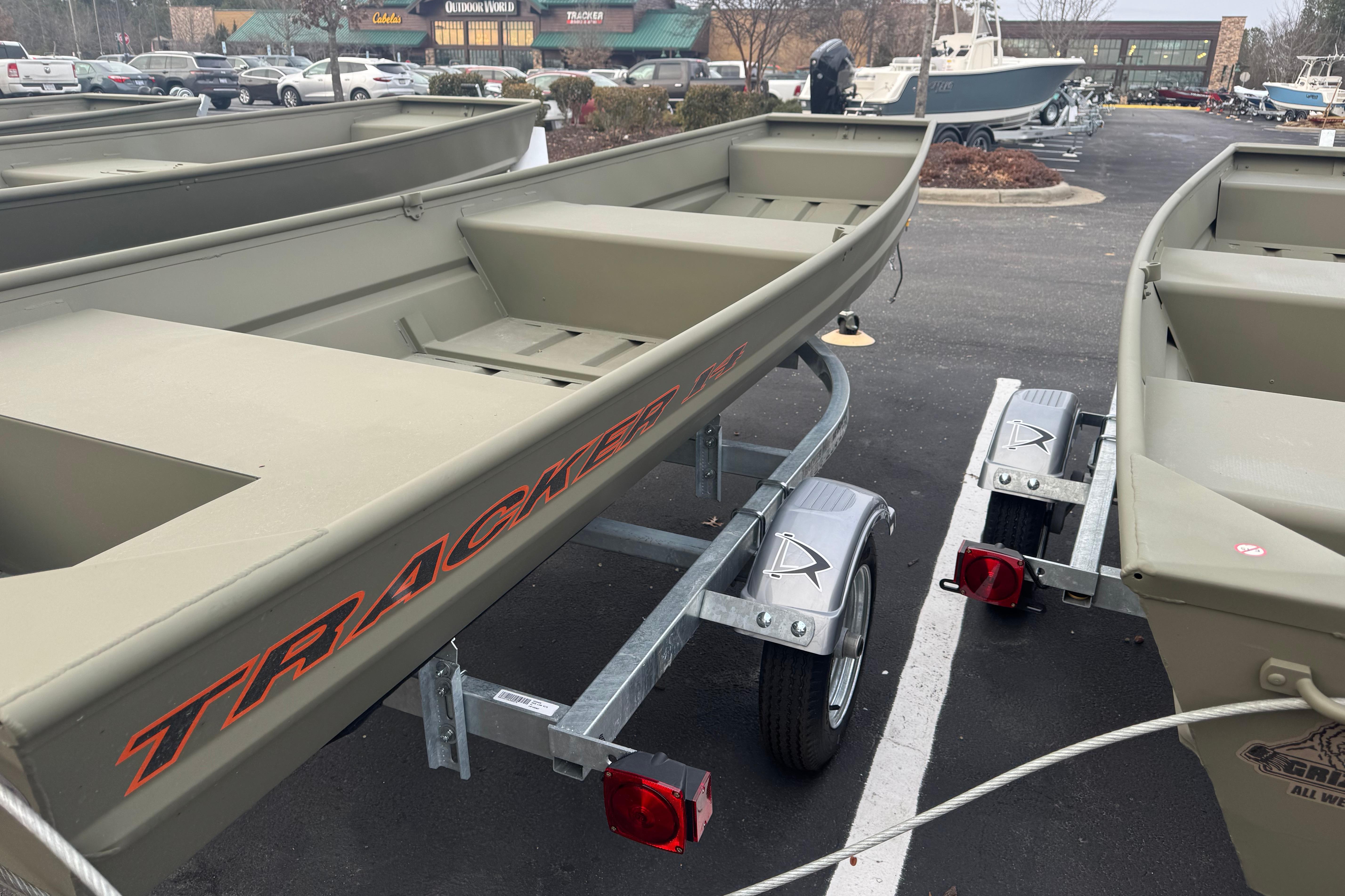 2026 Tracker Grizzly 14 Jon boat on trailer in parking lot.