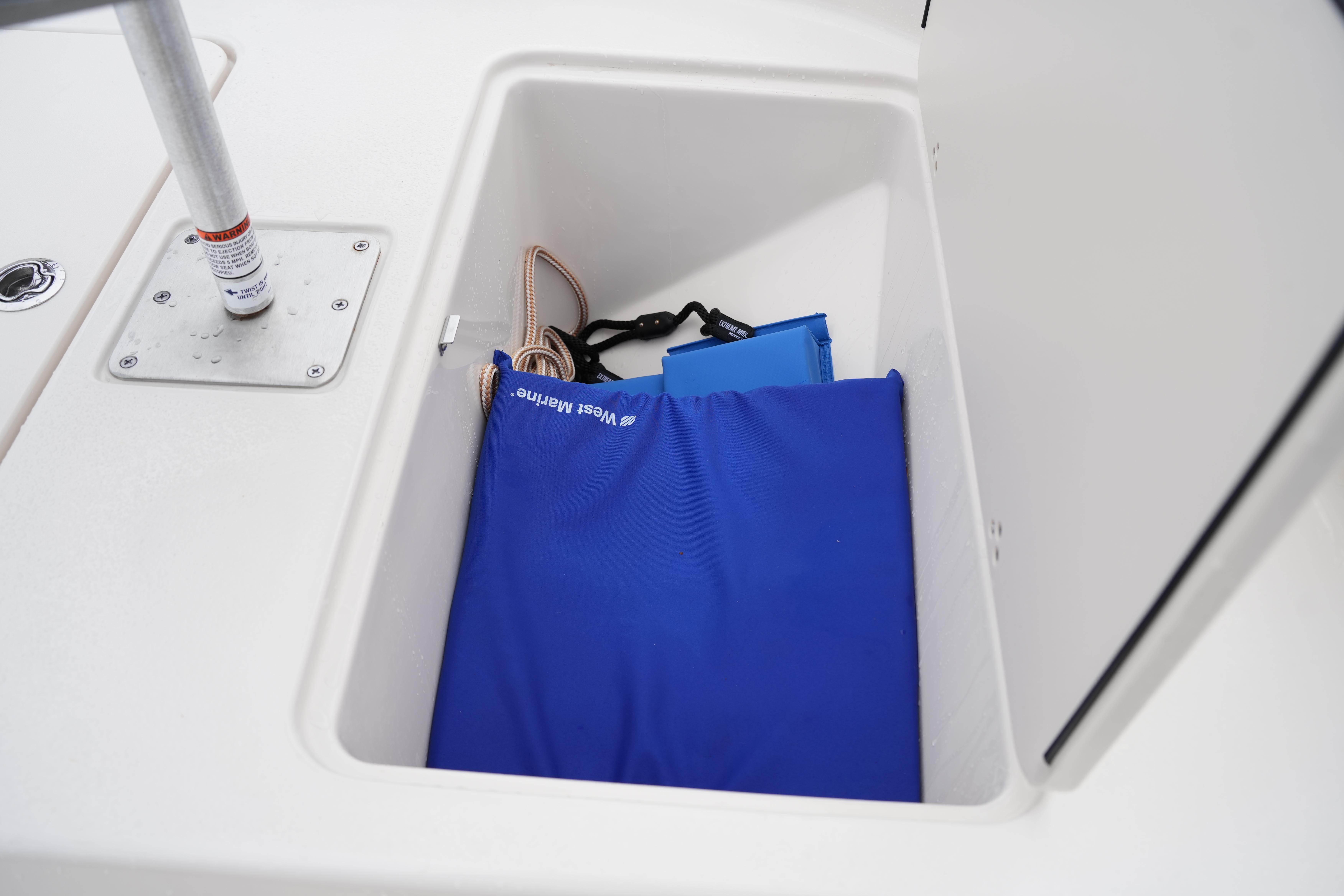 Storage compartment in 2025 Carolina Skiff 162 JLS boat with blue marine bag.