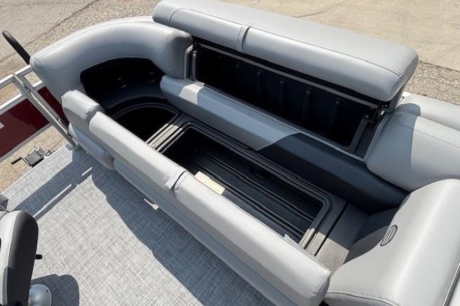2026 Sun Tracker SportFish 20 DLX pontoon boat with open storage compartments and gray seating.