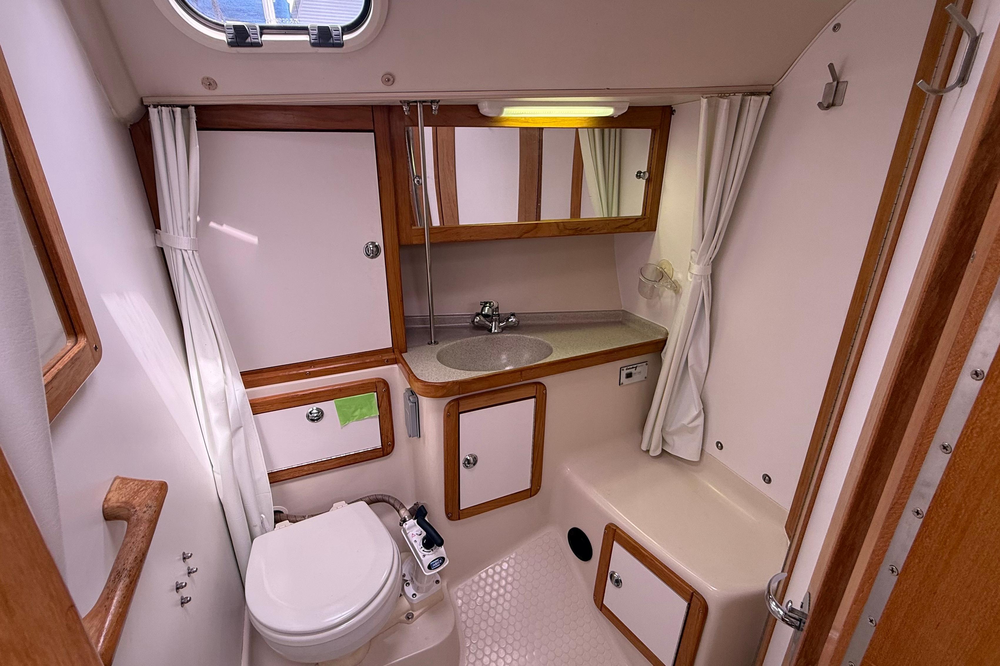 2005 Catalina 36 MkII yacht bathroom with sink, toilet, and wooden cabinetry.