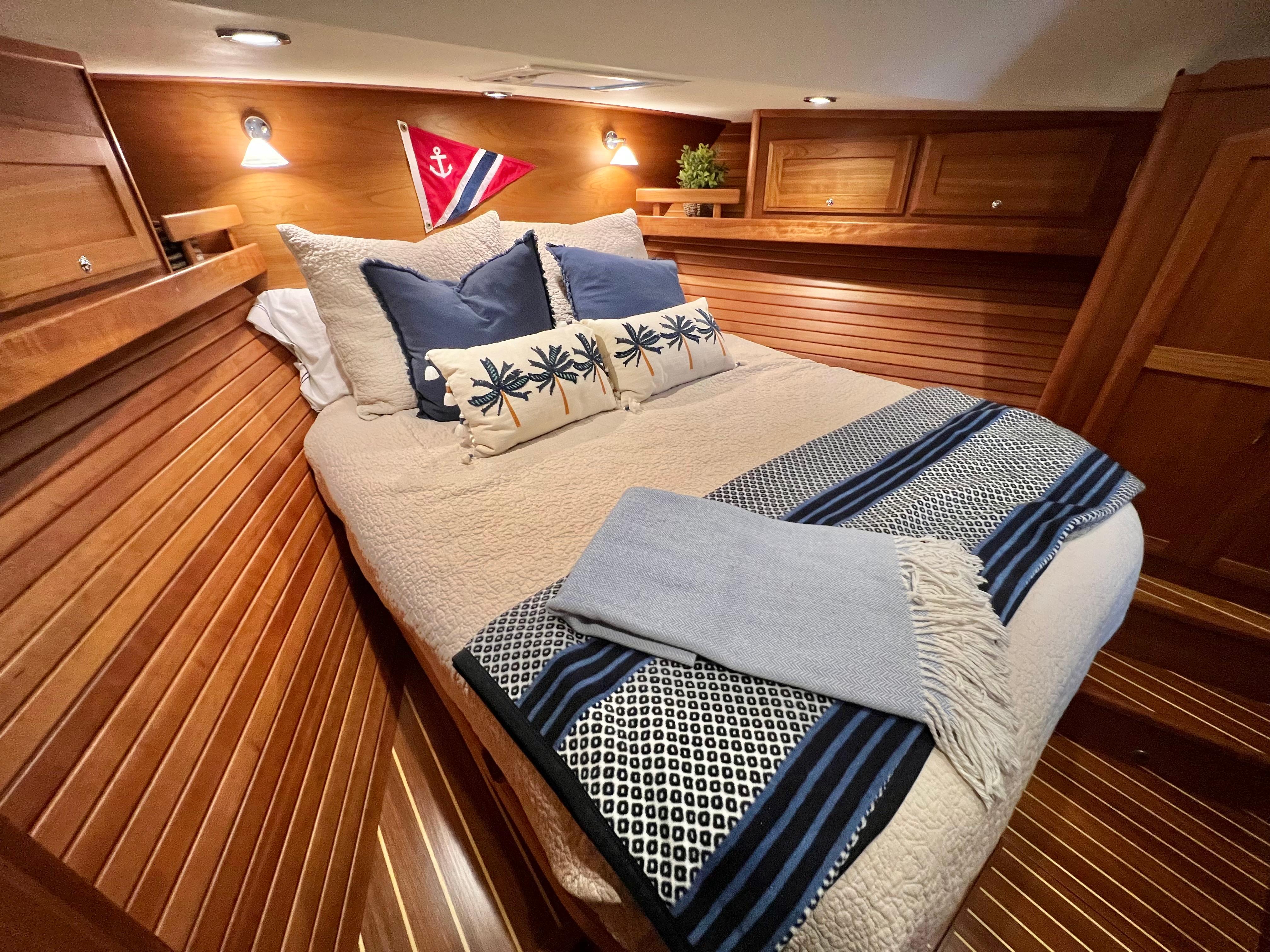 Cozy cabin interior of 2017 Sabre 48 Salon Express with elegant bedding and wooden paneling.