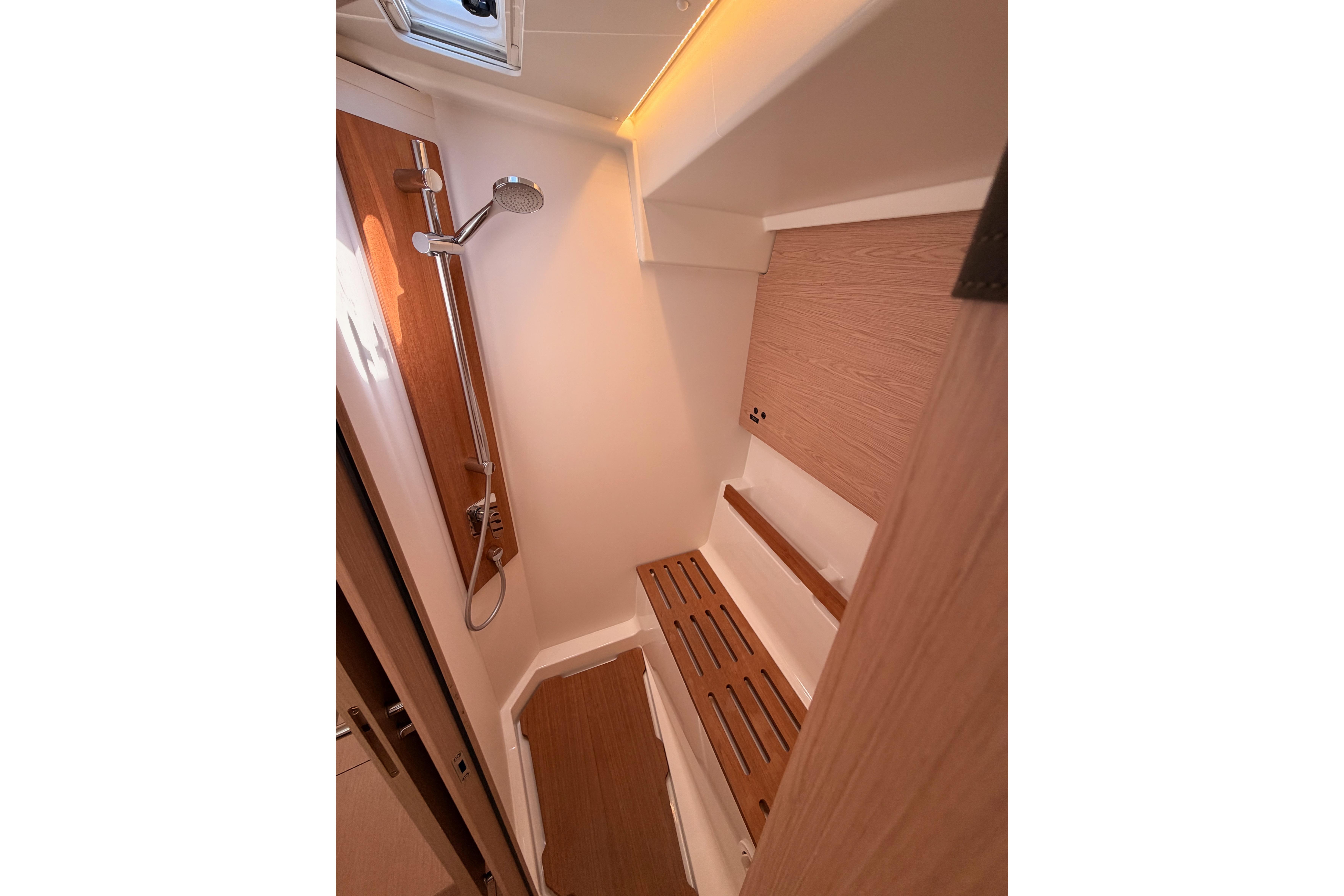 Shower area in 2022 Beneteau Oceanis Yacht 54, featuring wooden accents and modern fixtures.
