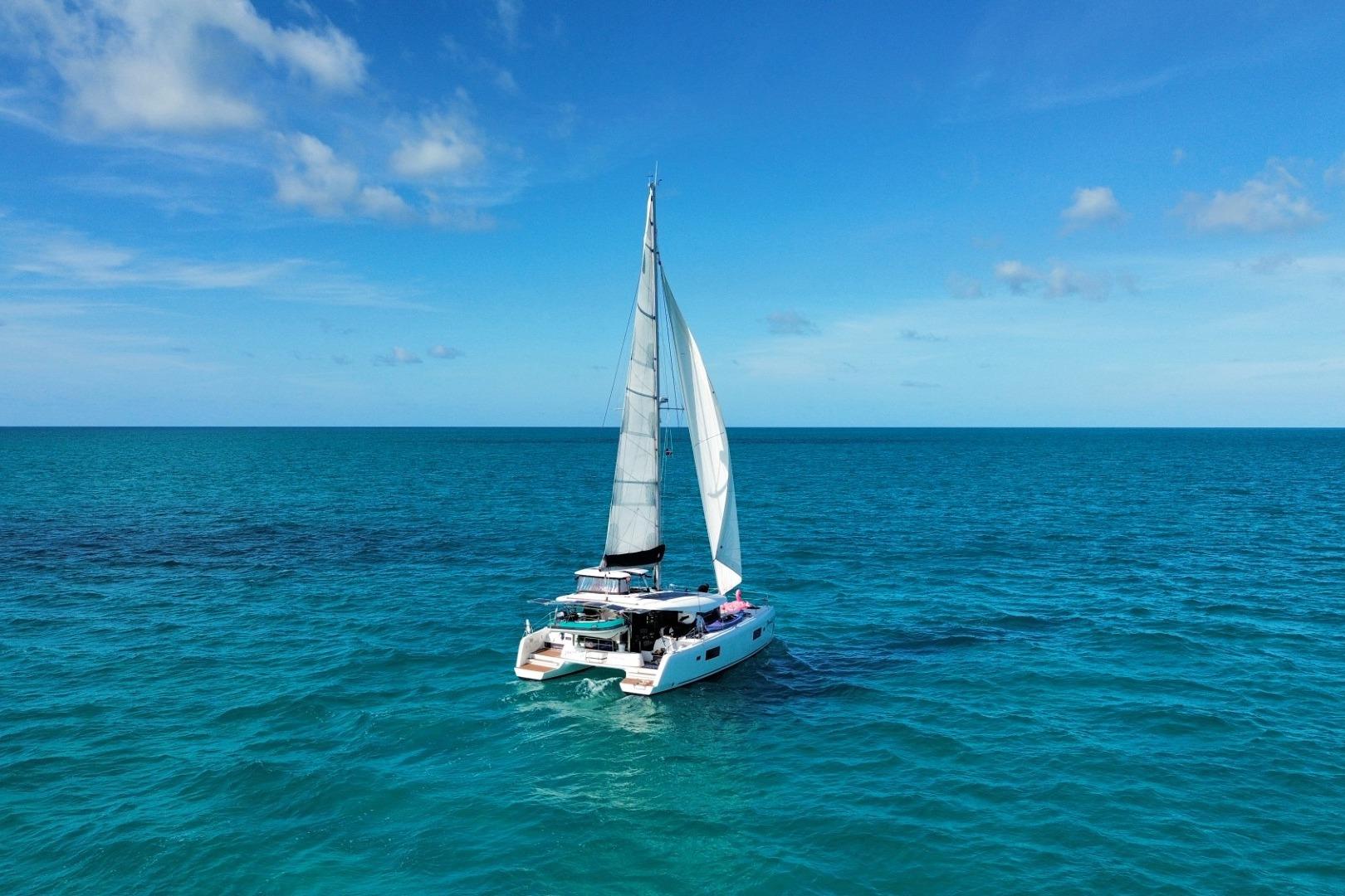 Sailing Lagoon 42 catamaran, 2018 model, on clear blue ocean under sunny skies.