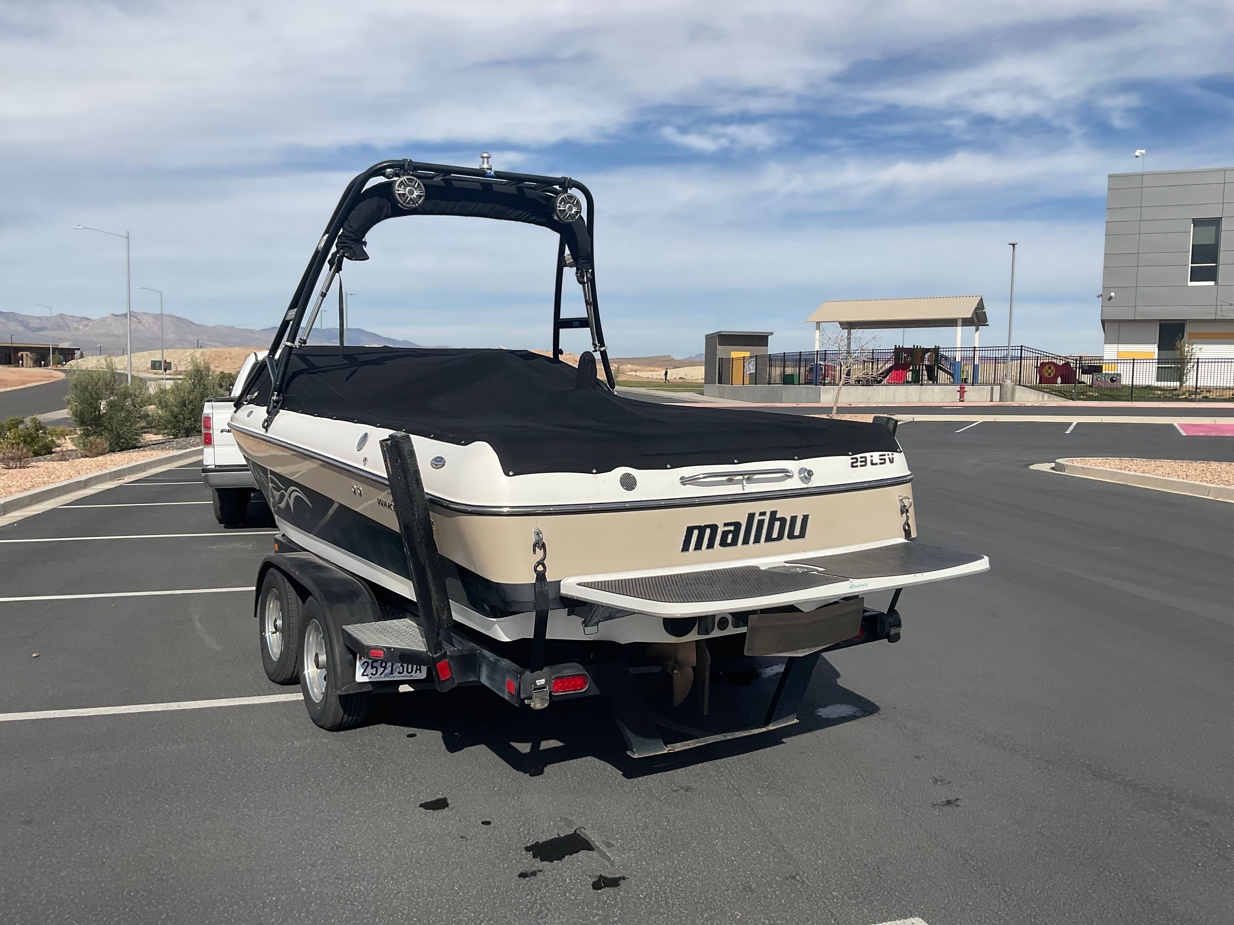 A 2003 Malibu Wakesetter 23 LSV on a trailer in a parking lot.