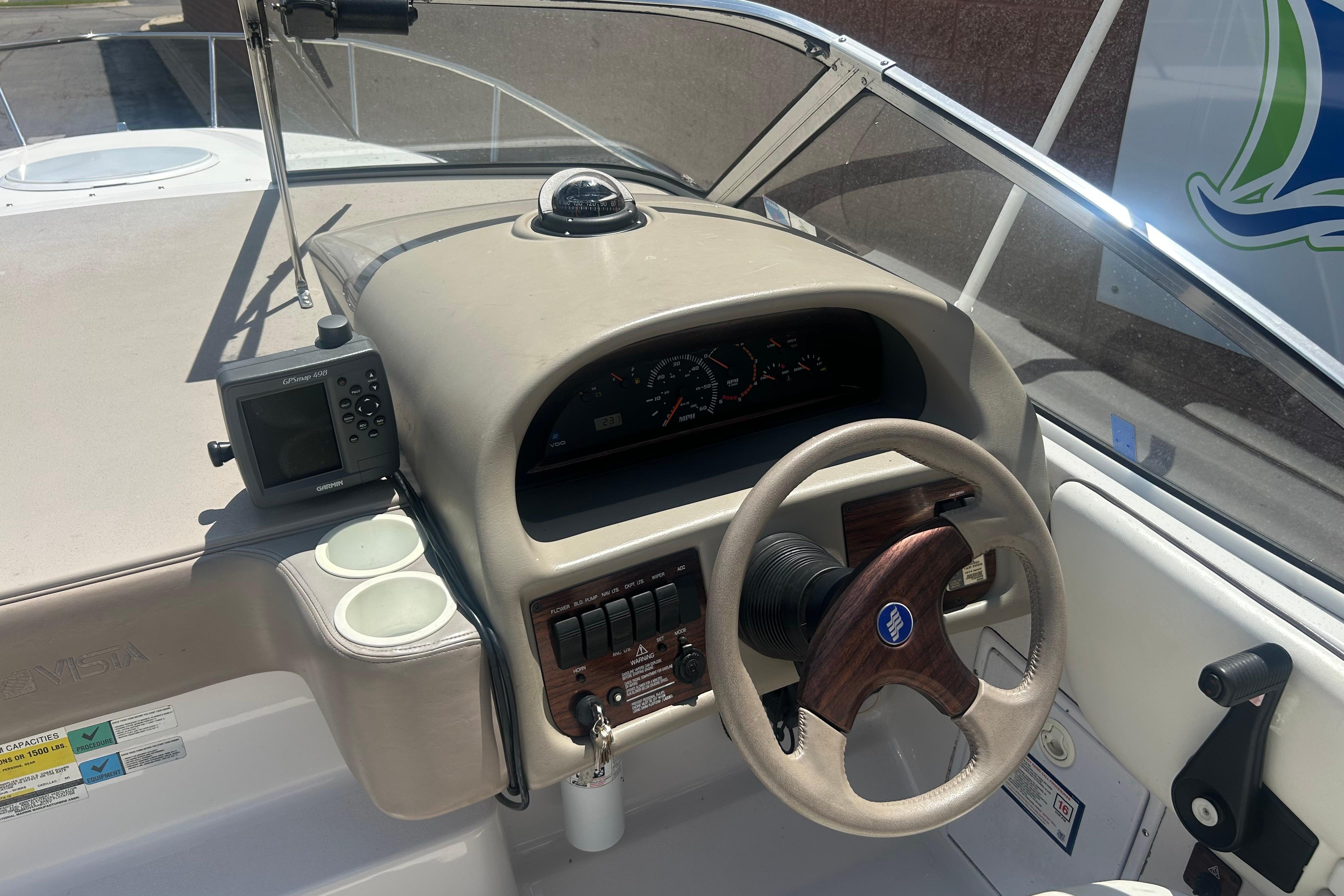 1998 Four Winns 258 Vista boat dashboard with steering wheel and navigation instruments.