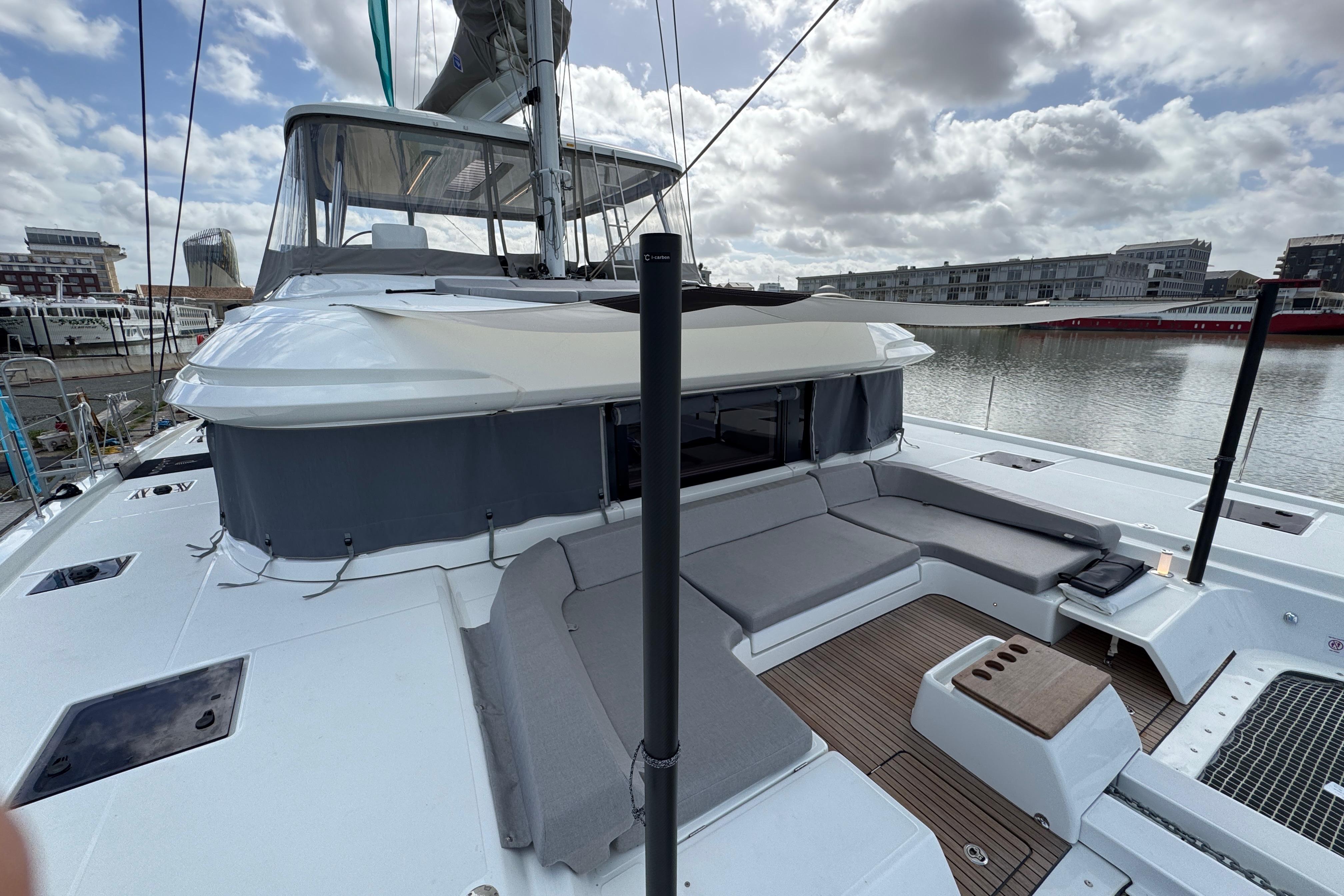 2026 Lagoon 55 yacht with spacious deck and modern seating, docked in a marina.