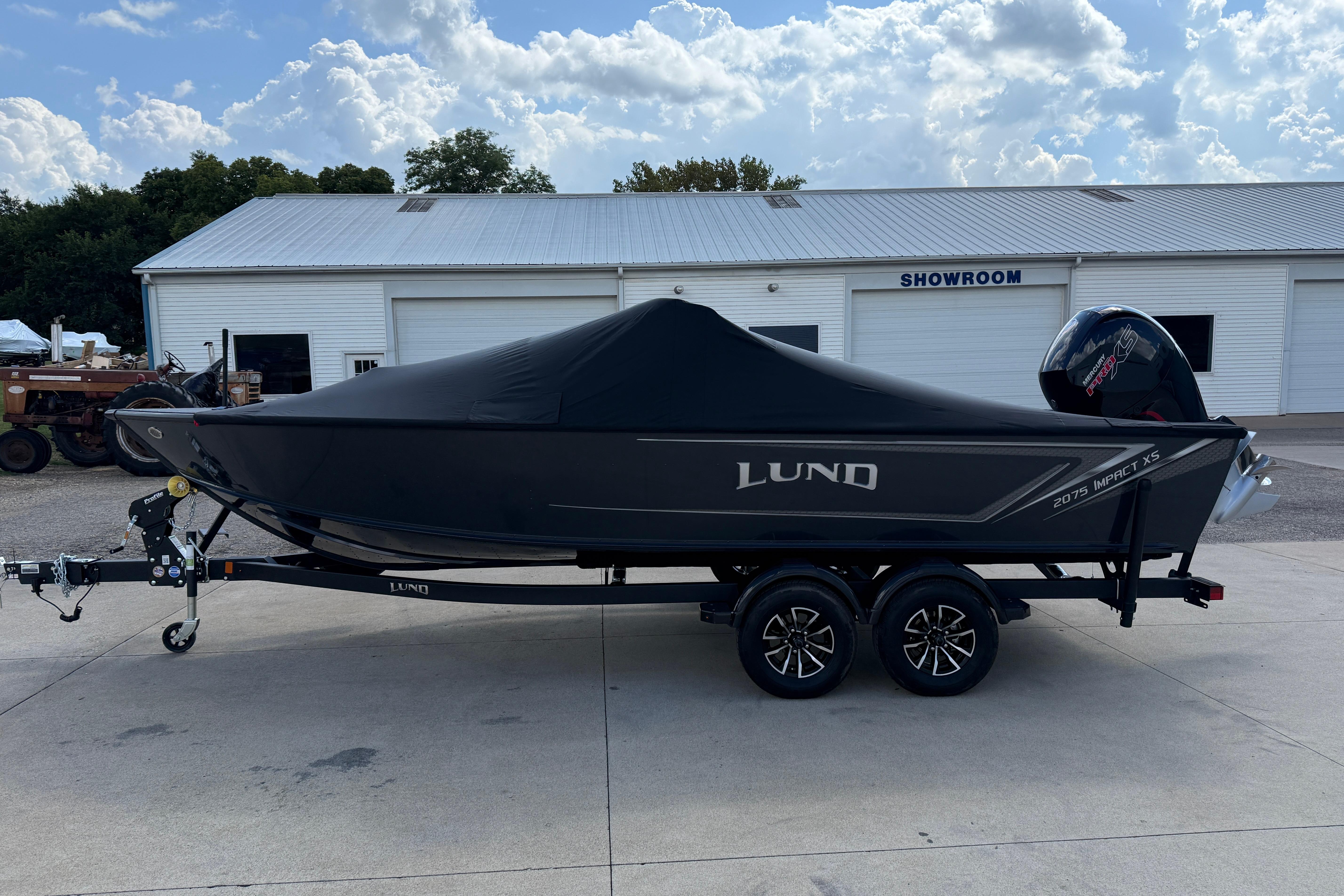 2026 Lund 2075 Impact XS boat on trailer, covered, outside showroom.