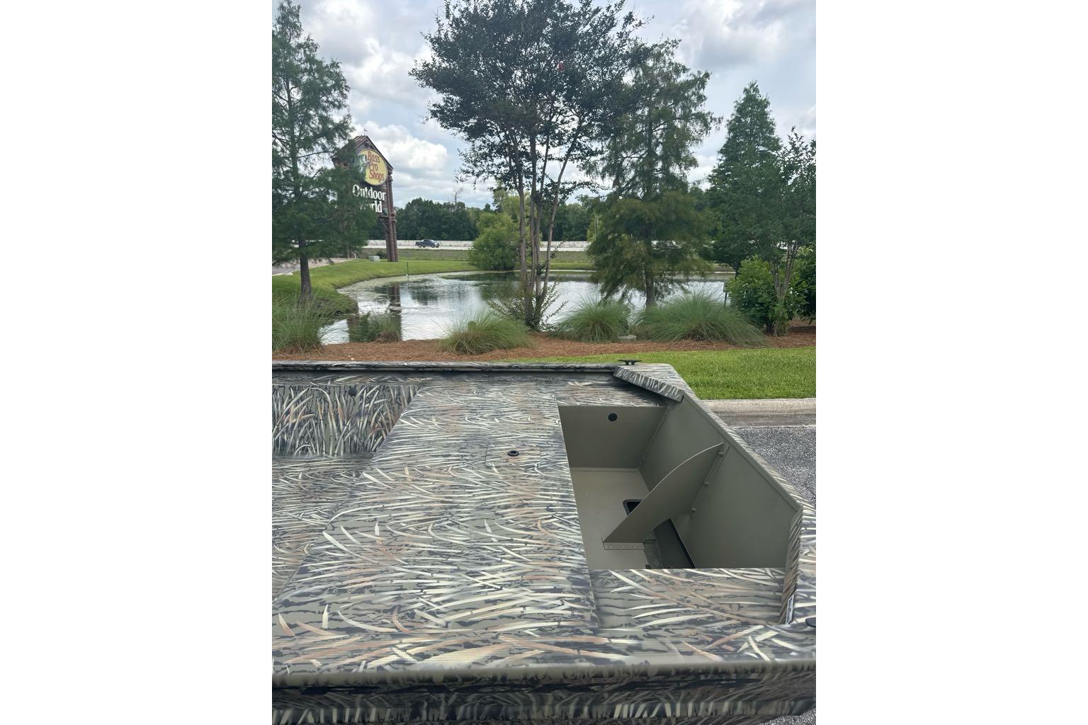 2026 Tracker Grizzly 1648 Utility boat near pond and trees, outdoor setting.