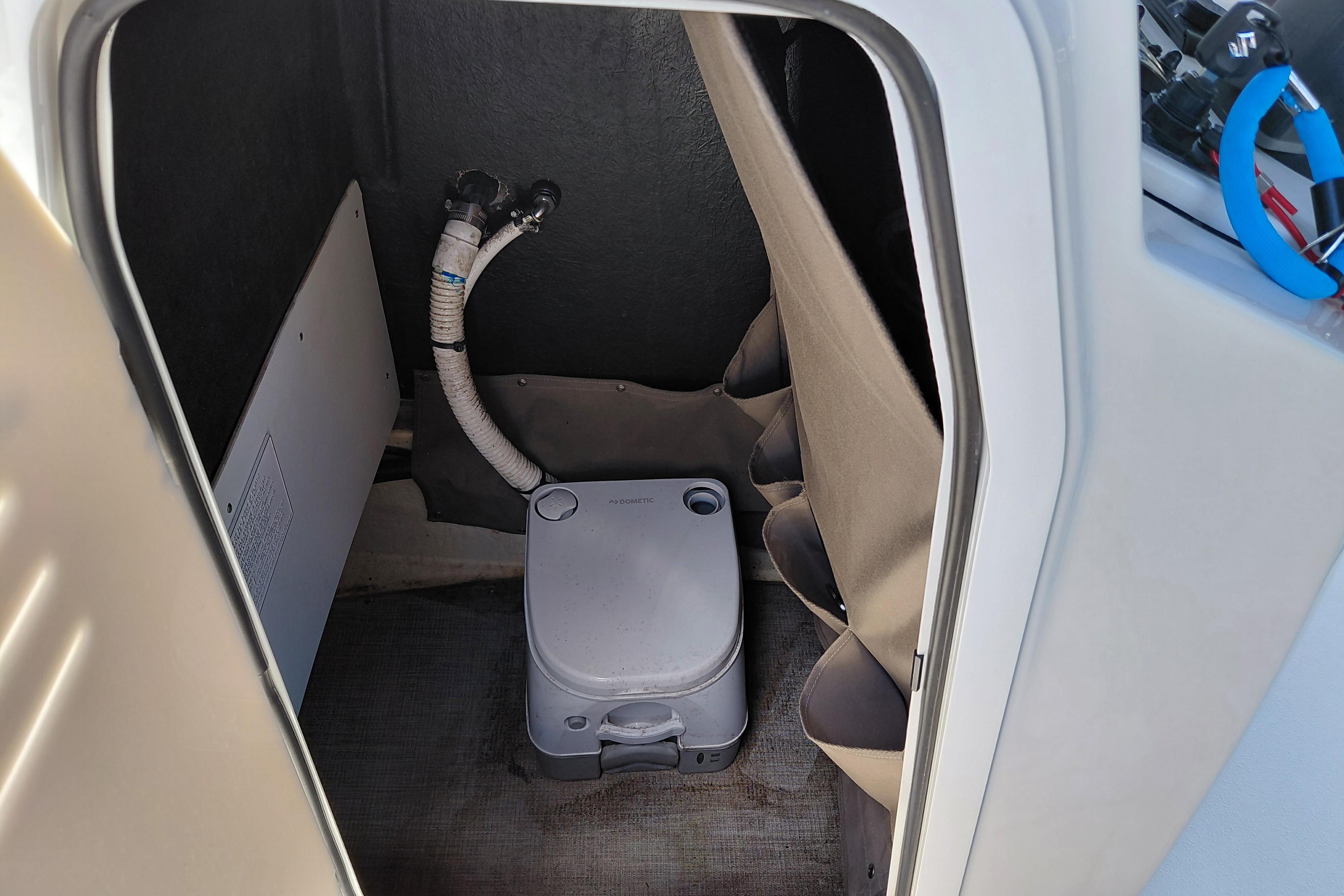 Compact cabin toilet in 2023 Stingray 206 CC boat interior.