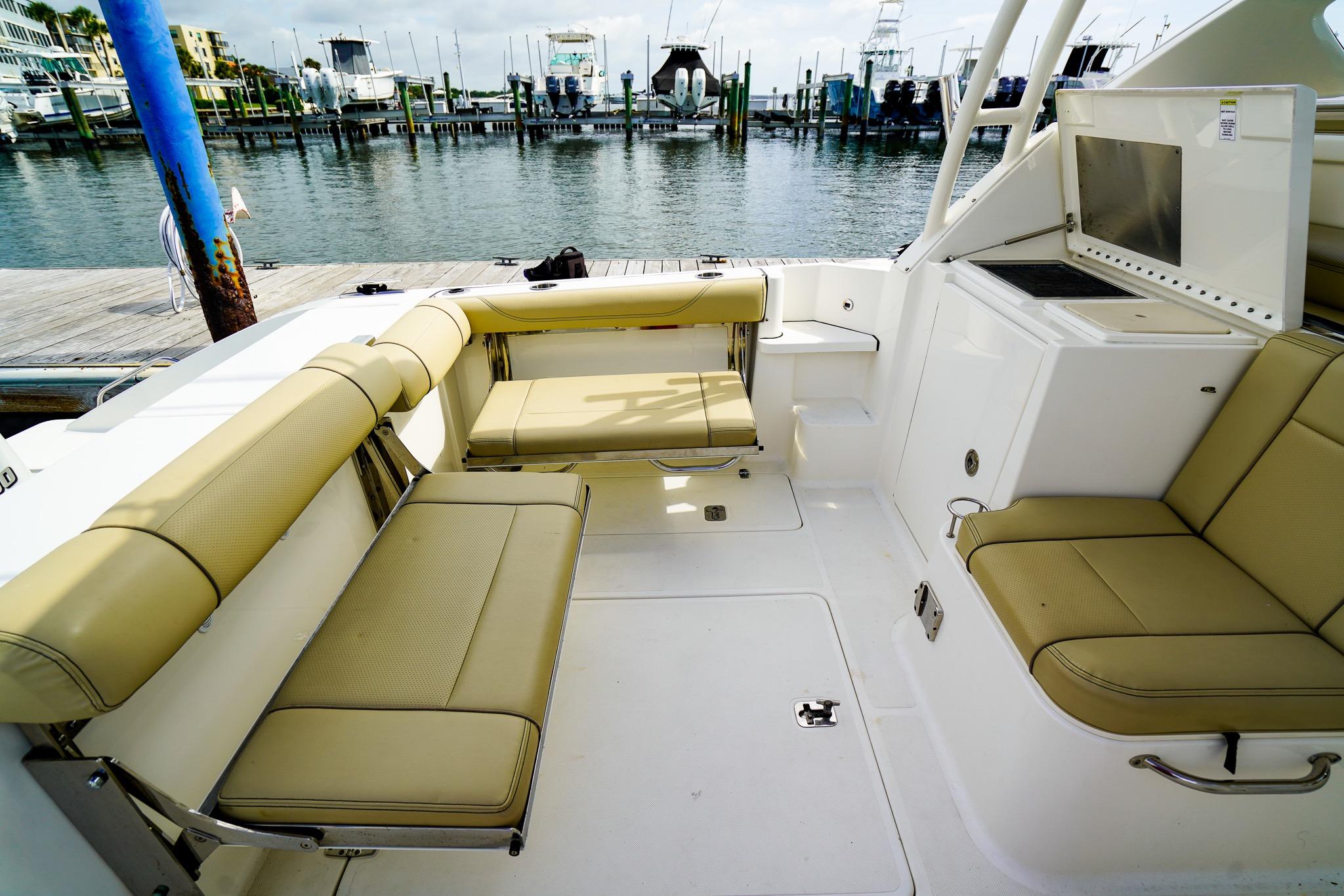 2020 Pursuit OS 325 Offshore boat interior with beige seating, docked at marina.