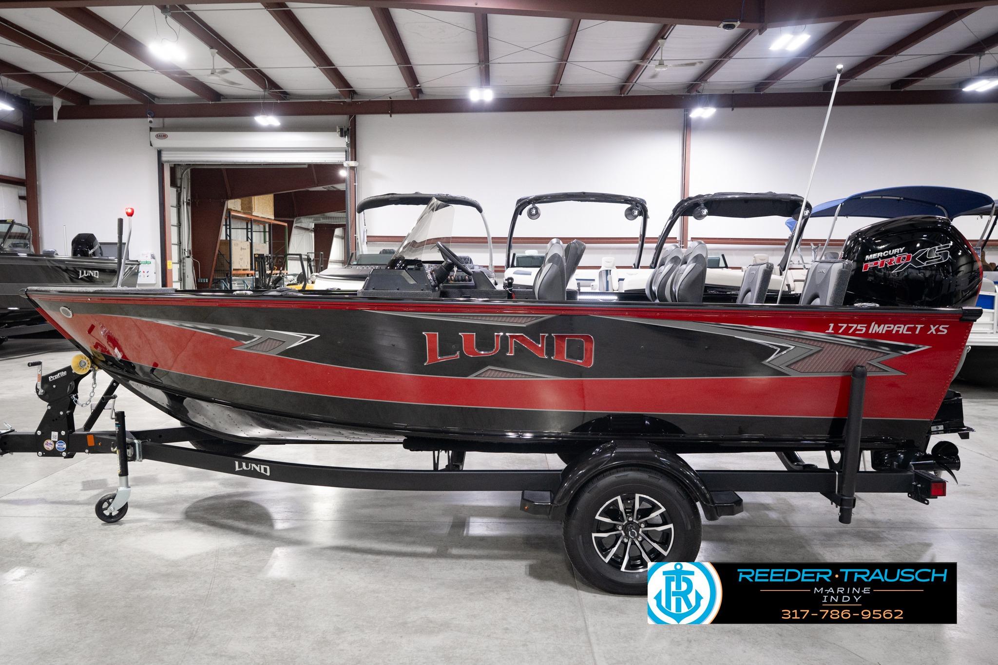 2026 Lund 1775 Impact XS SS boat in showroom, featuring sleek red and black design.