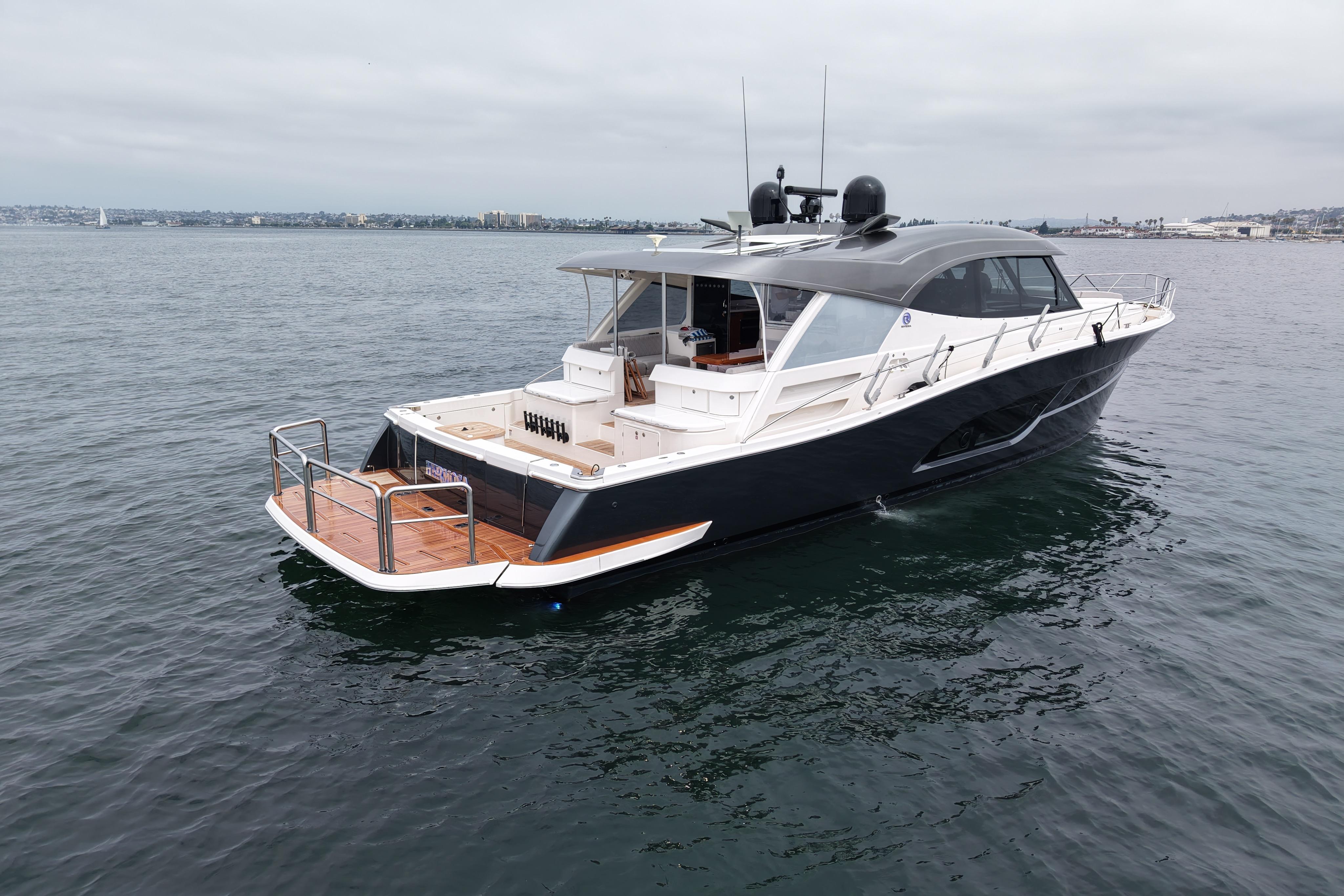 2023 Riviera 645 SUV luxury yacht on calm waters, showcasing sleek design and spacious deck.