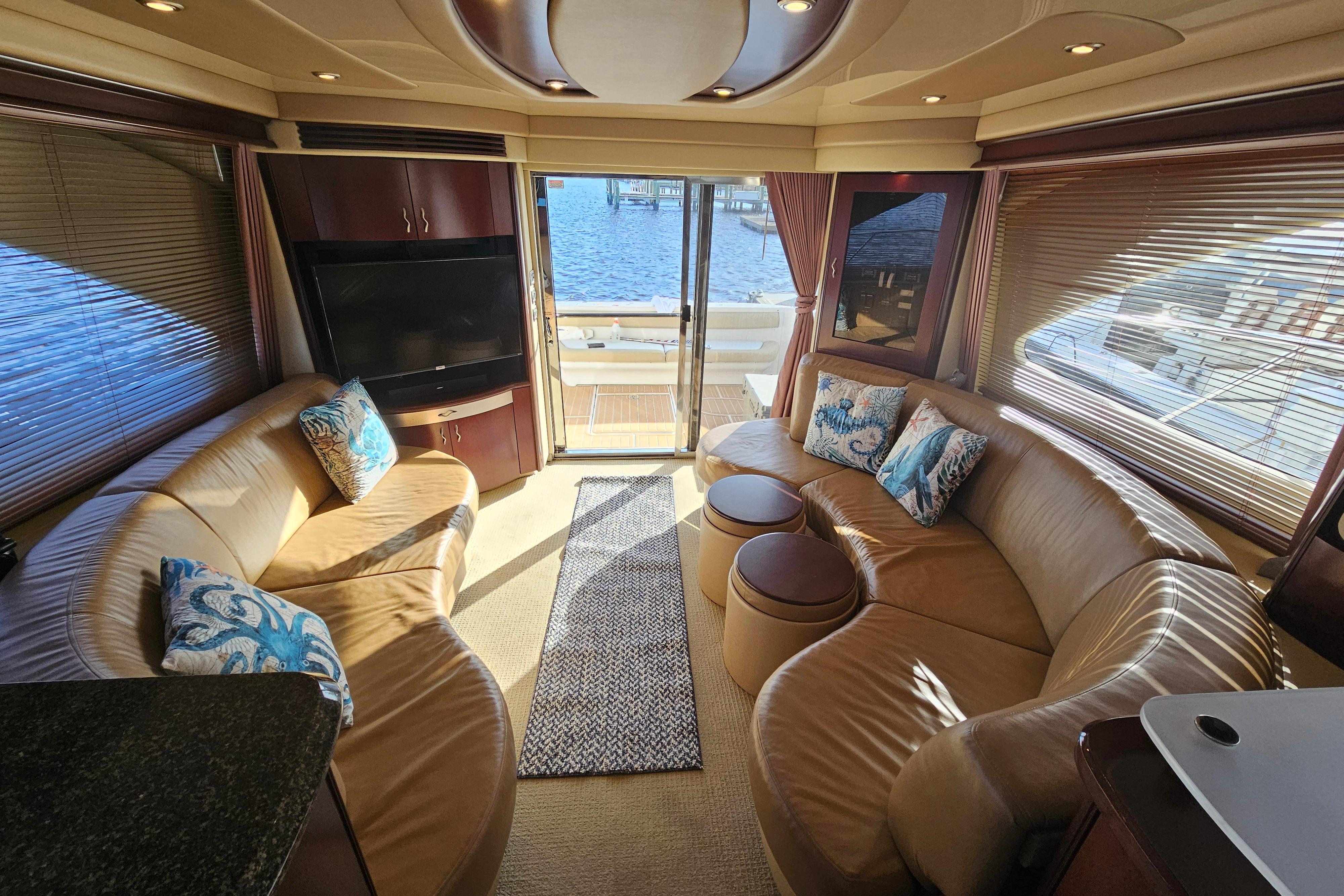 Luxurious interior of 2006 Sea Ray 580 Sedan Bridge yacht with leather seating and waterfront view.