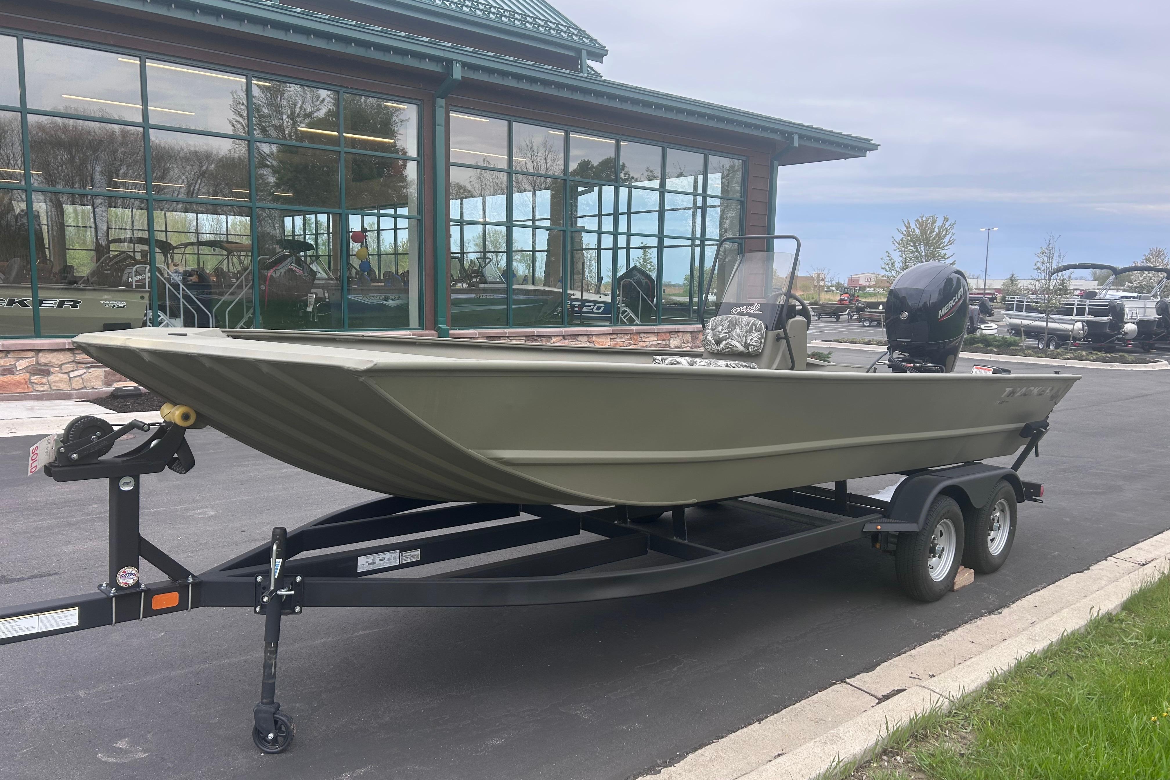2024 Tracker Grizzly 2072 CC boat on trailer outside showroom.