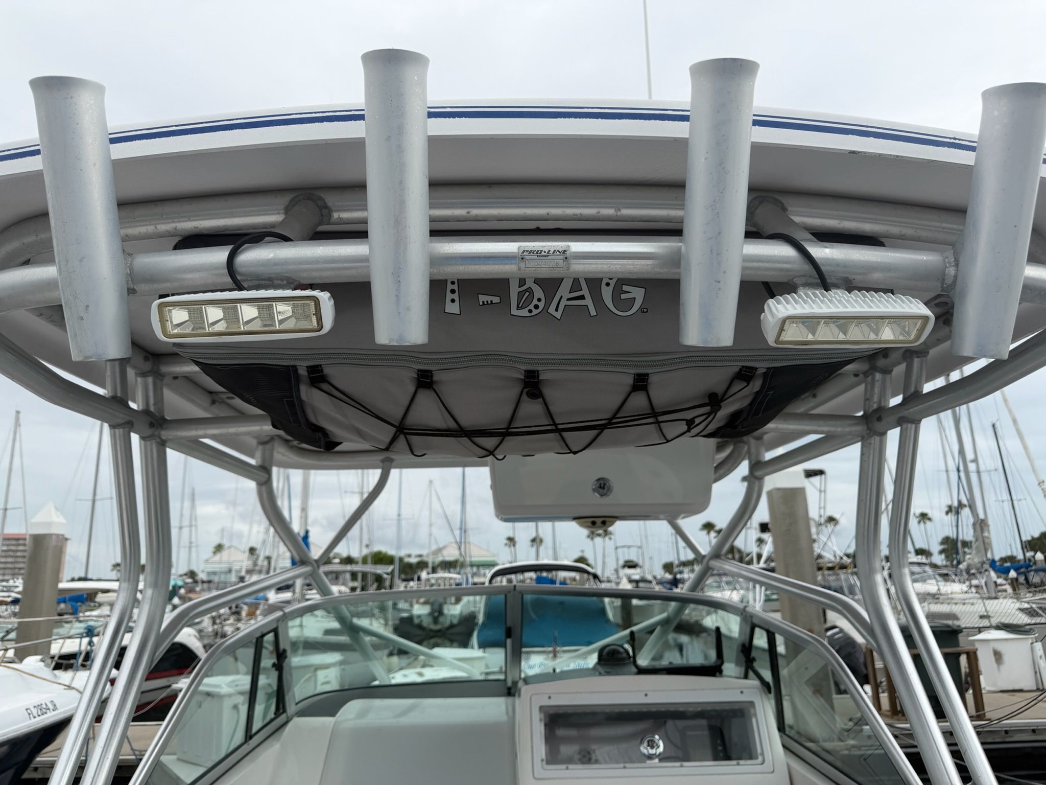 A 2003 Pro-Drive Walkaround with sturdy T-top and fishing rod holders, docked at a marina.